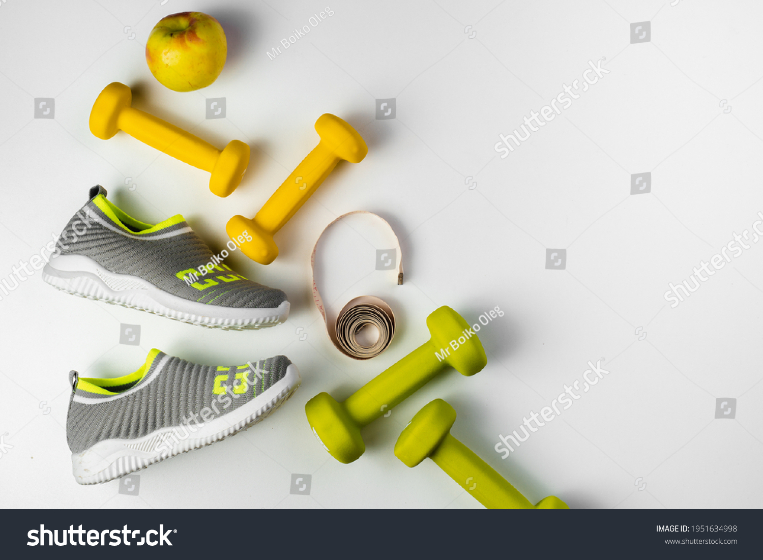 Gym and workout, 
sports shoes, sneakers, Healthy lifestyle concept foto. Flat lay of sport. Athlete's set with centimeter tape, green apple and dumbbells on a grey background #1951634998