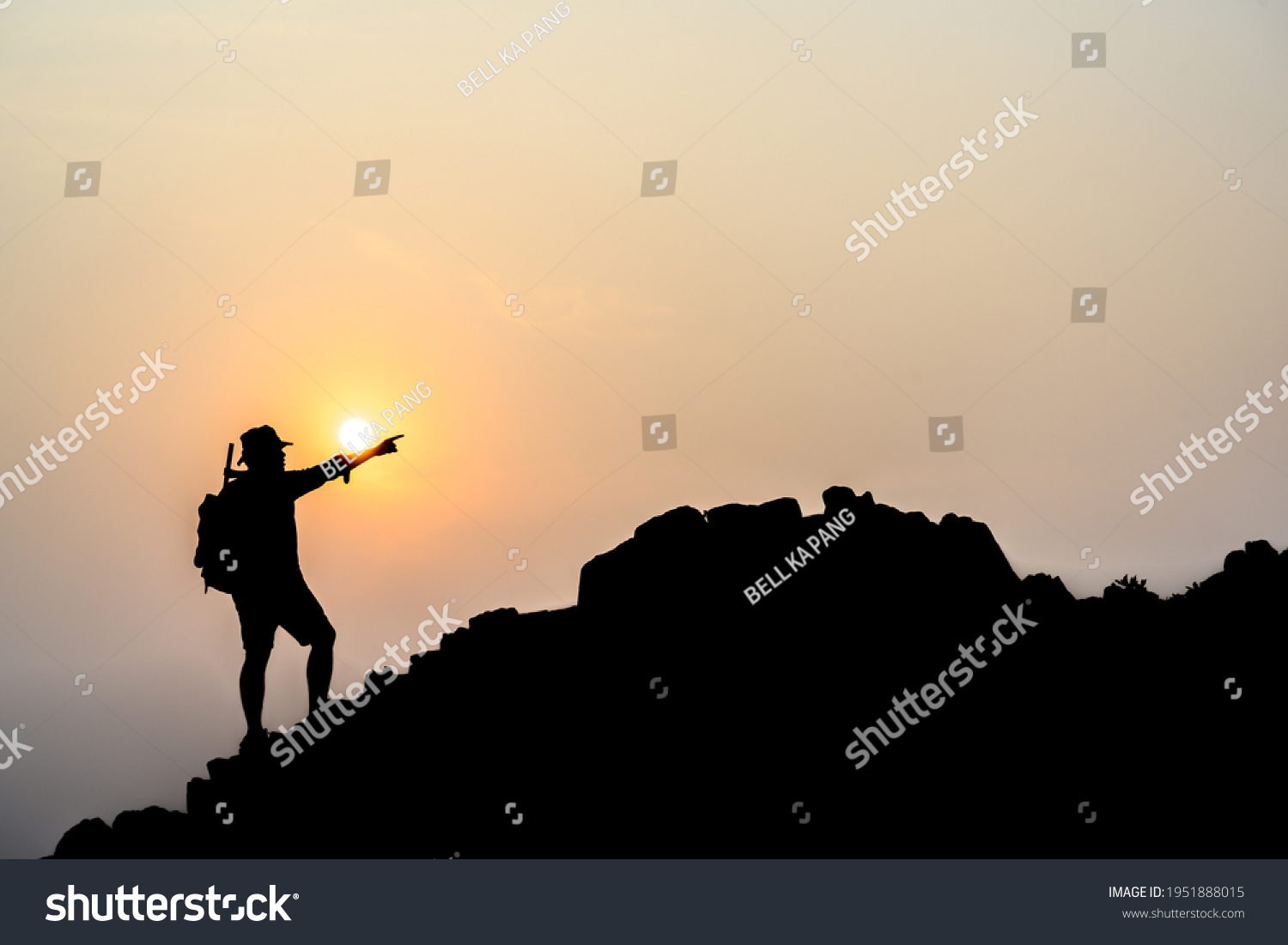 Silhouette of young male tourists Stand and watch the beautiful sunset on top of the mountain with your backpack. #1951888015