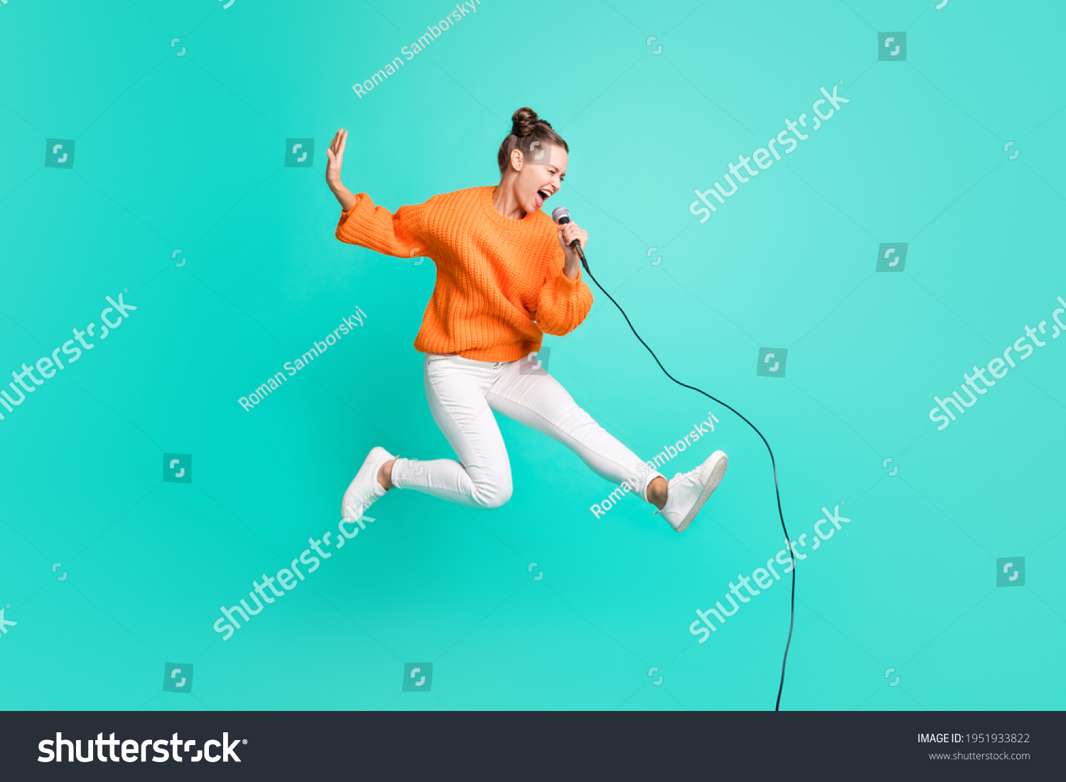 Full size profile side photo of young crazy screaming girl jumping singing in microphone isolated on turquoise color background #1951933822
