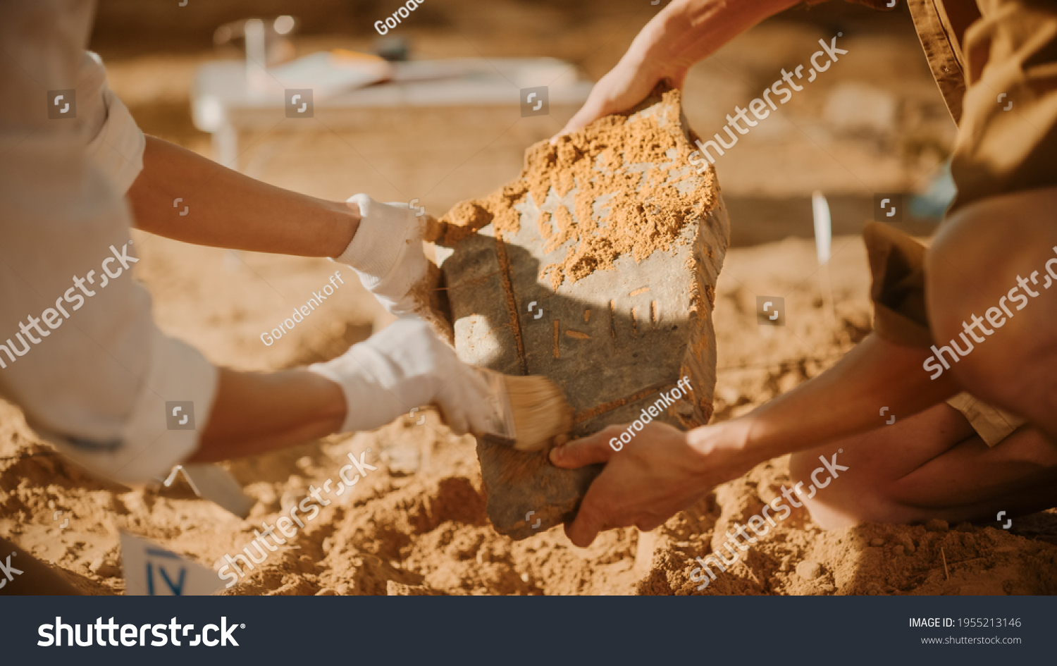 Archeological Digging Site: Two Great Archeologists Work on Excavation Site, Carefully Cleaning, Holding Newly Discovered Ancient Civilization Cultural Artifact, Historic Clay Tablet, Fossil Remains #1955213146