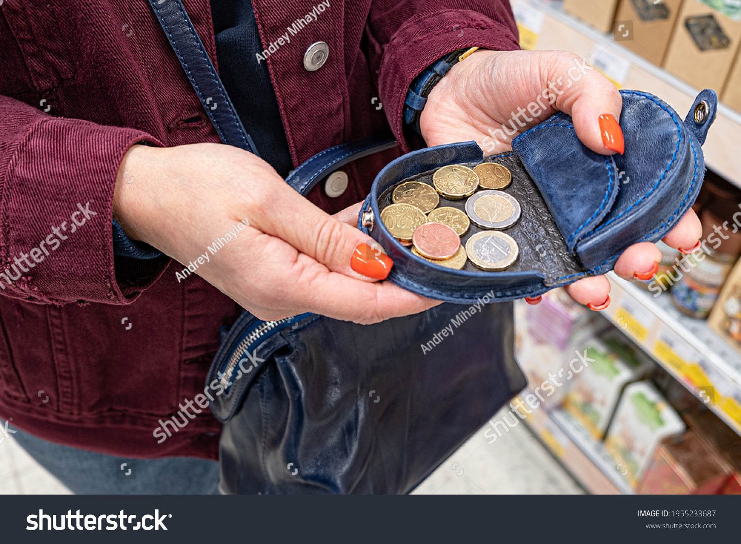 A woman holds a purse with several coins in her hand. After paying for purchases in the store, check in hand. #1955233687