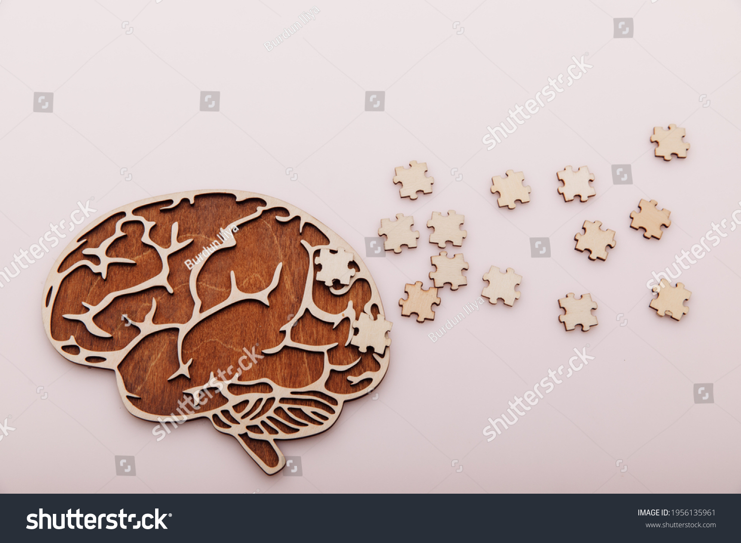 Alzheimer's disease and mental health concept. Brain and wooden puzzle on a pink background #1956135961