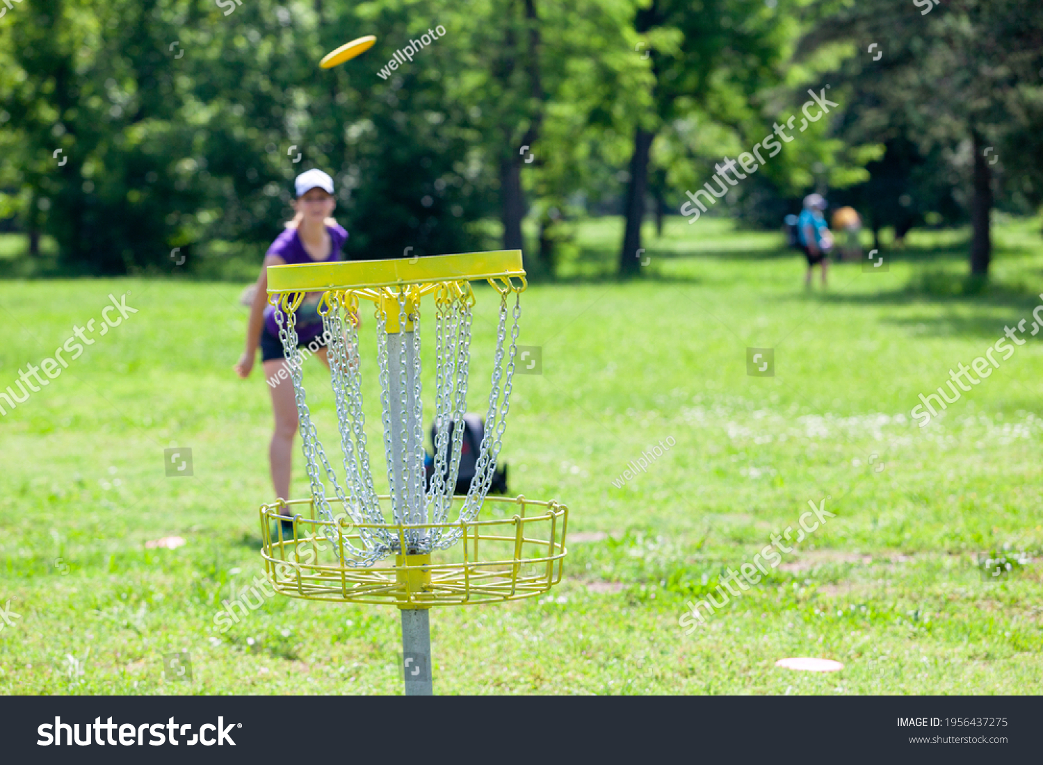 Young woman playing flying disc sport game in the park #1956437275