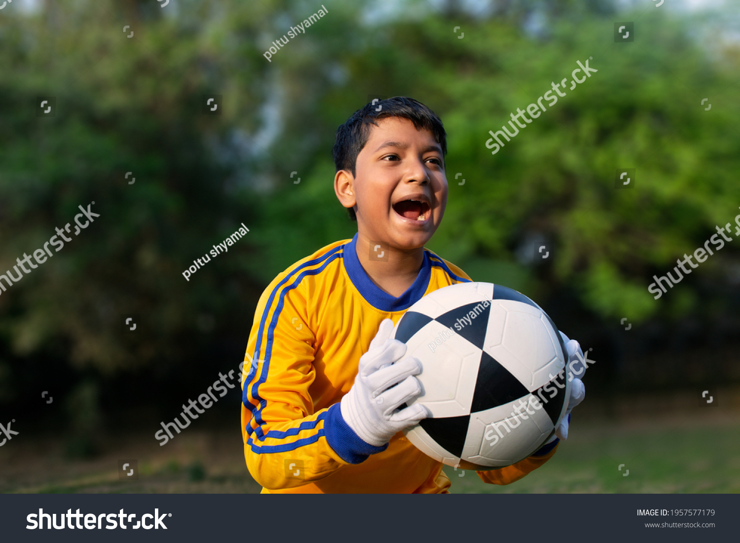 Excited boy football player Holding scored ball #1957577179