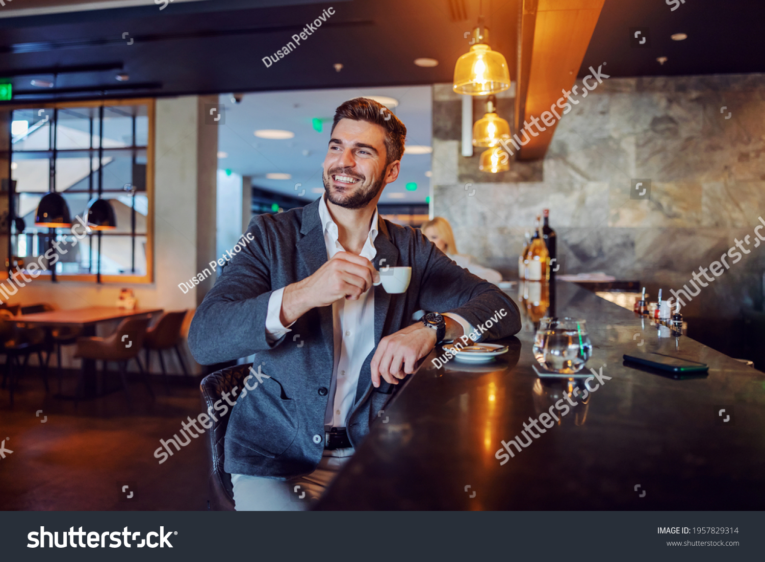 The happy middle-aged man in elegant formal clothes sitting in a hotel cafe and having his afternoon coffee. Coffee break, don't worry be happy, positive attitude and vibes #1957829314