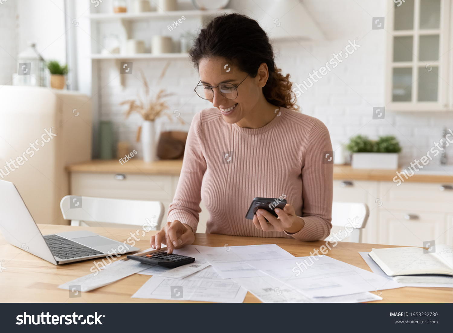 Young latina female work with financial papers at home count on calculator before paying taxes receipts online by phone. Millennial woman planning budget glad to find chance for economy saving money #1958232730
