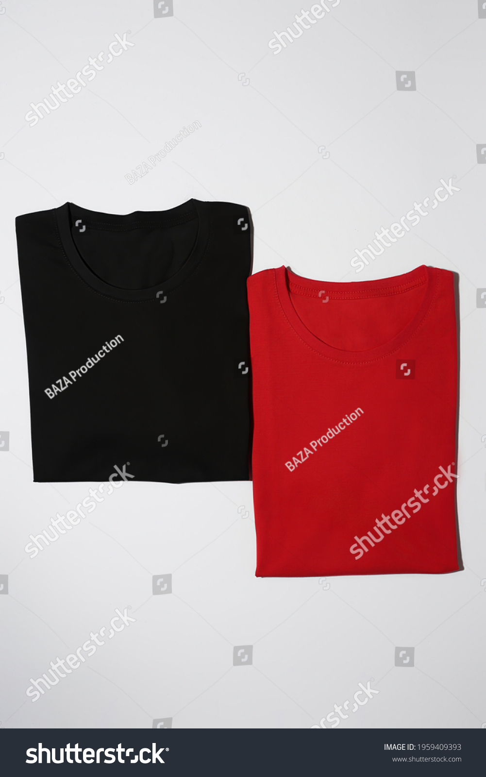 Two folded colorful black and red cotton t shirts isolated on white background. Flat lay tees template. Clothes, fashion, retail concept. Vertical shot #1959409393