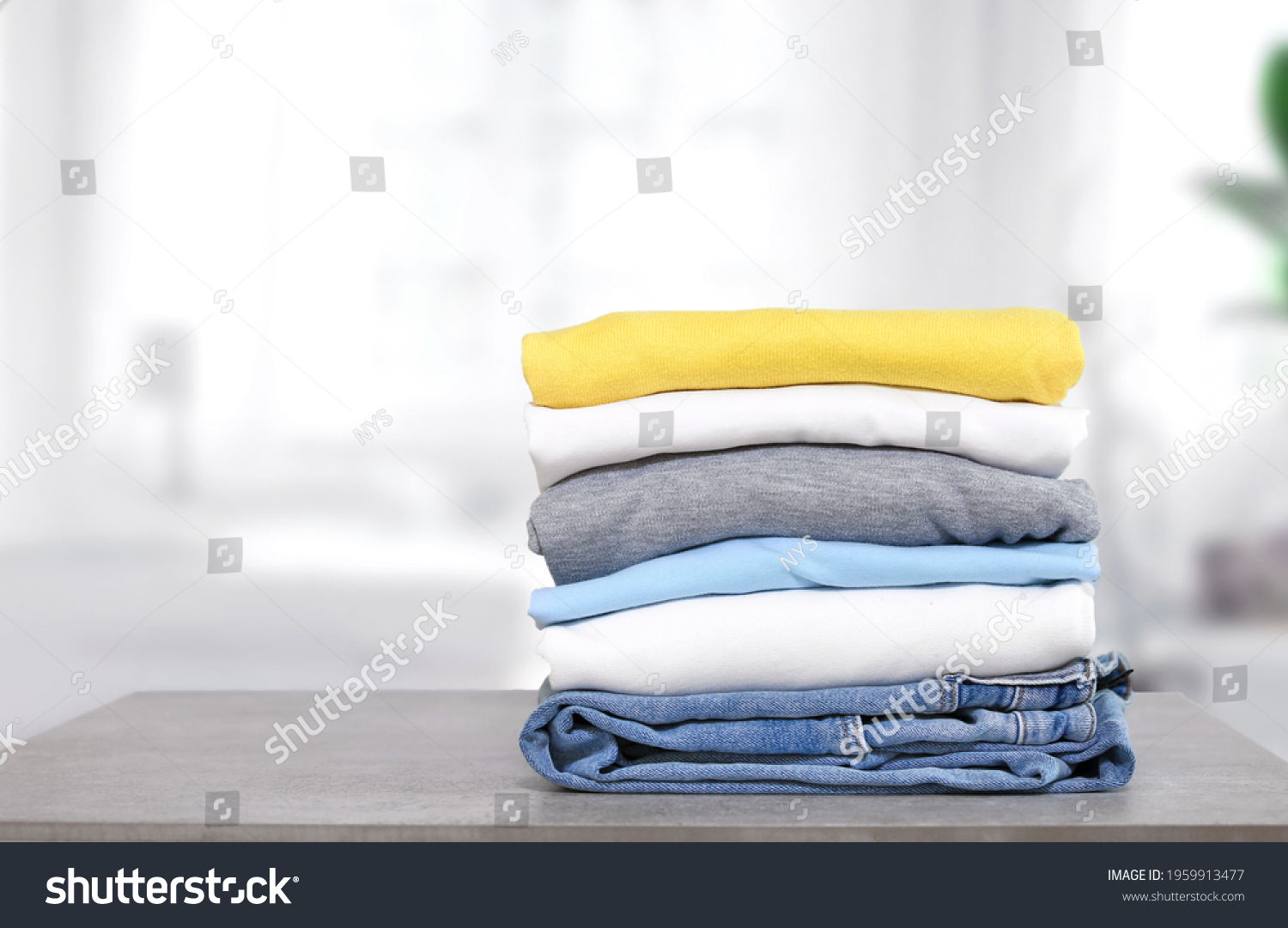 Stack of cotton colorful clothes on table indoors.Stacked apparel.Folded clean clothing.Household. #1959913477