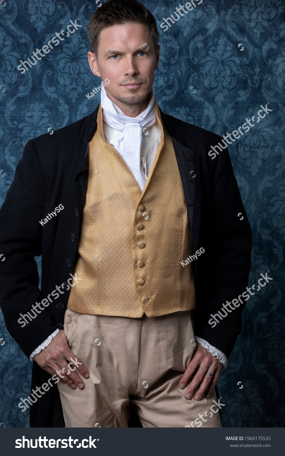 A handsome Regency gentleman wearing a gold waistcoat and black jacket and standing in a room with blue wallpaper and a wooden floor #1960175533