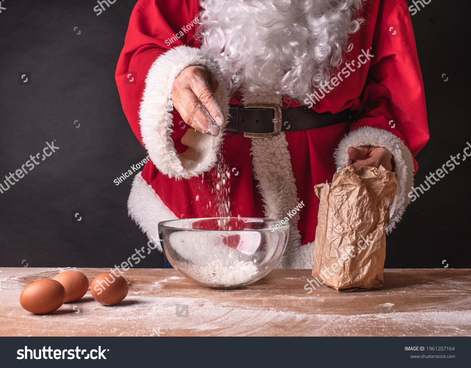 Santa preparing to bake pancakes, pastries. Red santa clothes on a black background. #1961207164