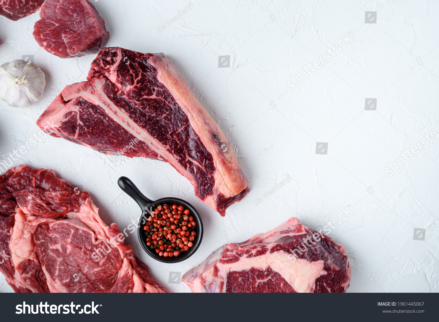 Various cuts of marbled beef meat and dry aged steaks set, tomahawk, t bone, club steak, rib eye and tenderloin cuts, on white stone background, top view flat lay, with copy space for text #1961445067