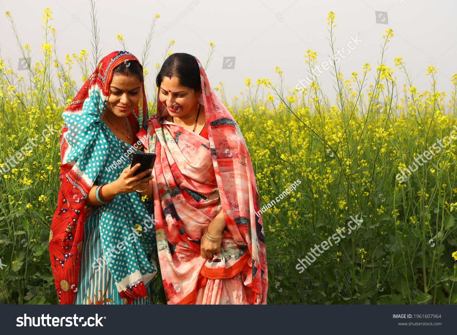 Indian rural ladies using phone in village #1961607964