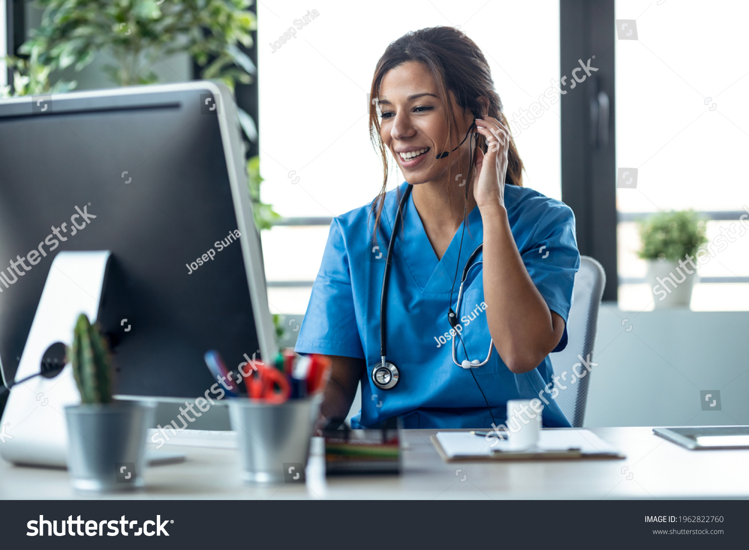 Shot of female doctor talking with earphone while explaining medical treatment to patient through a video call with computer in the consultation. #1962822760