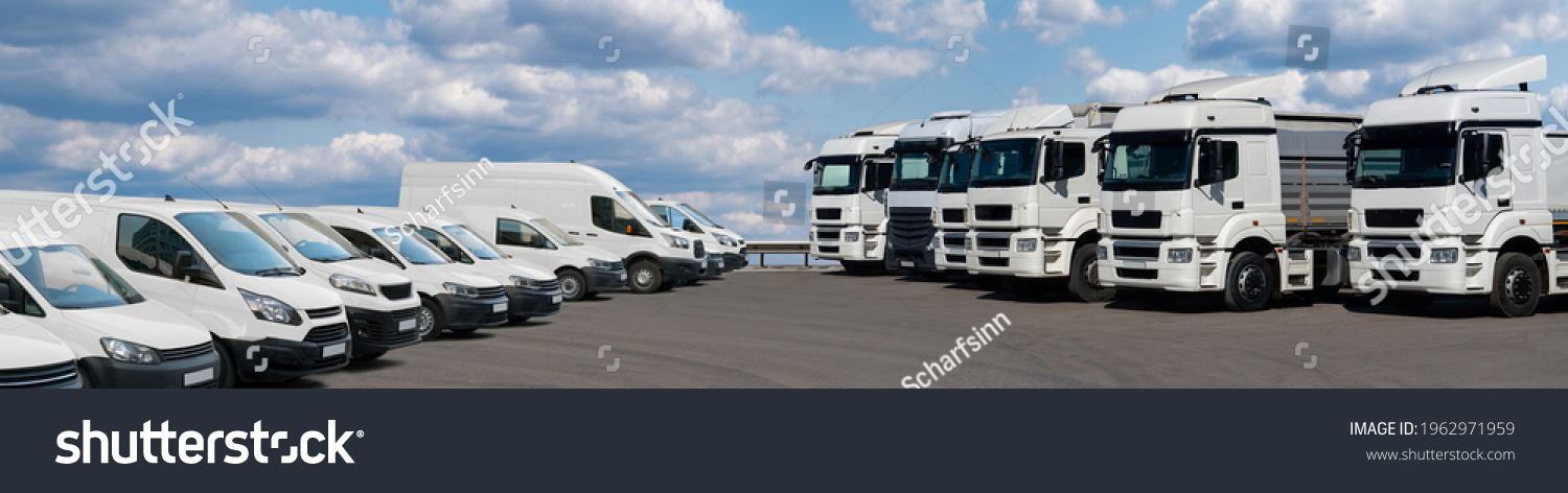 Semi trucks and delivery vans are parked in rows. Commercial fleet #1962971959