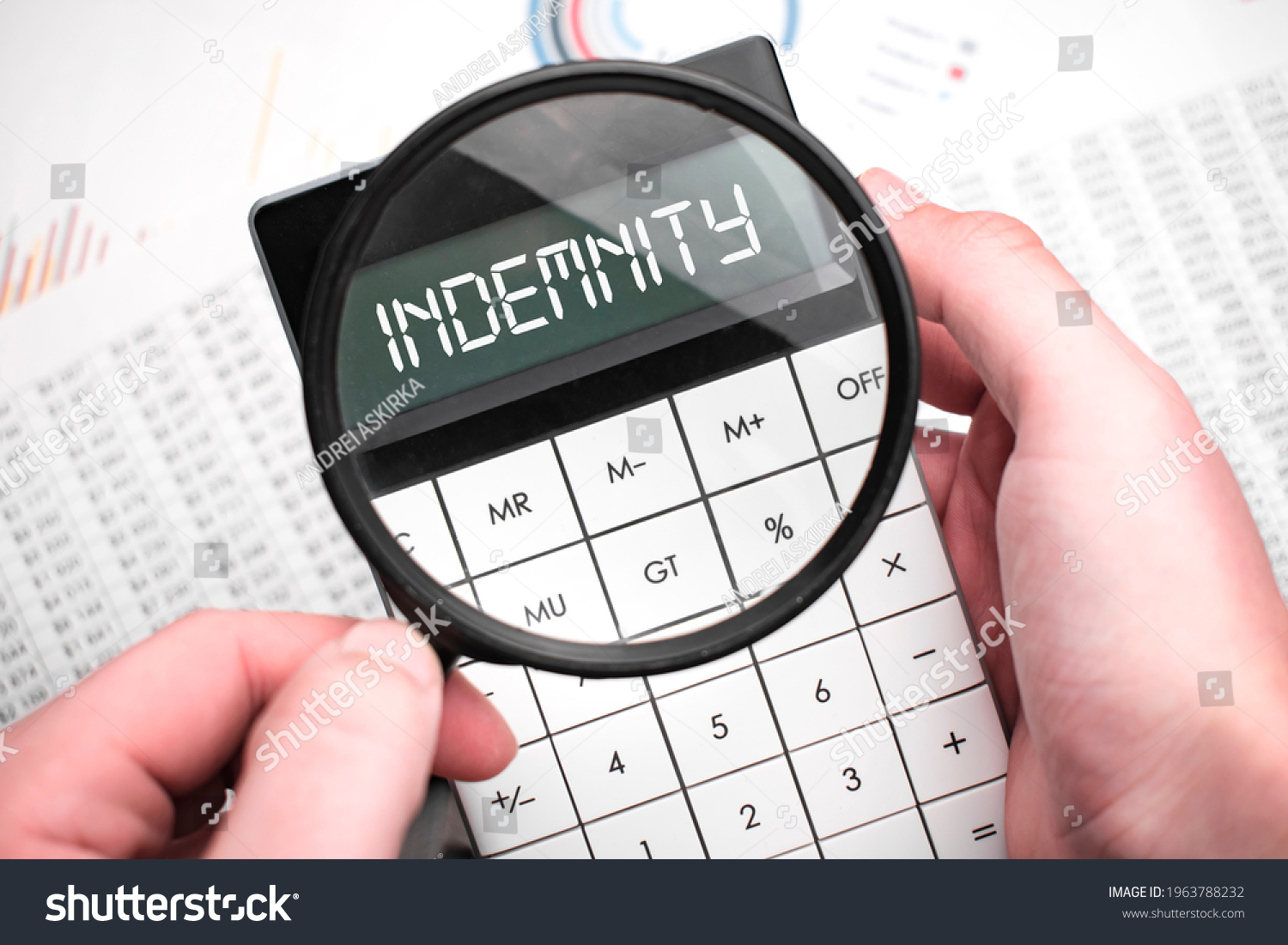 The word indemnity is written on the calculator. Business man holding a calculator in his hand. #1963788232