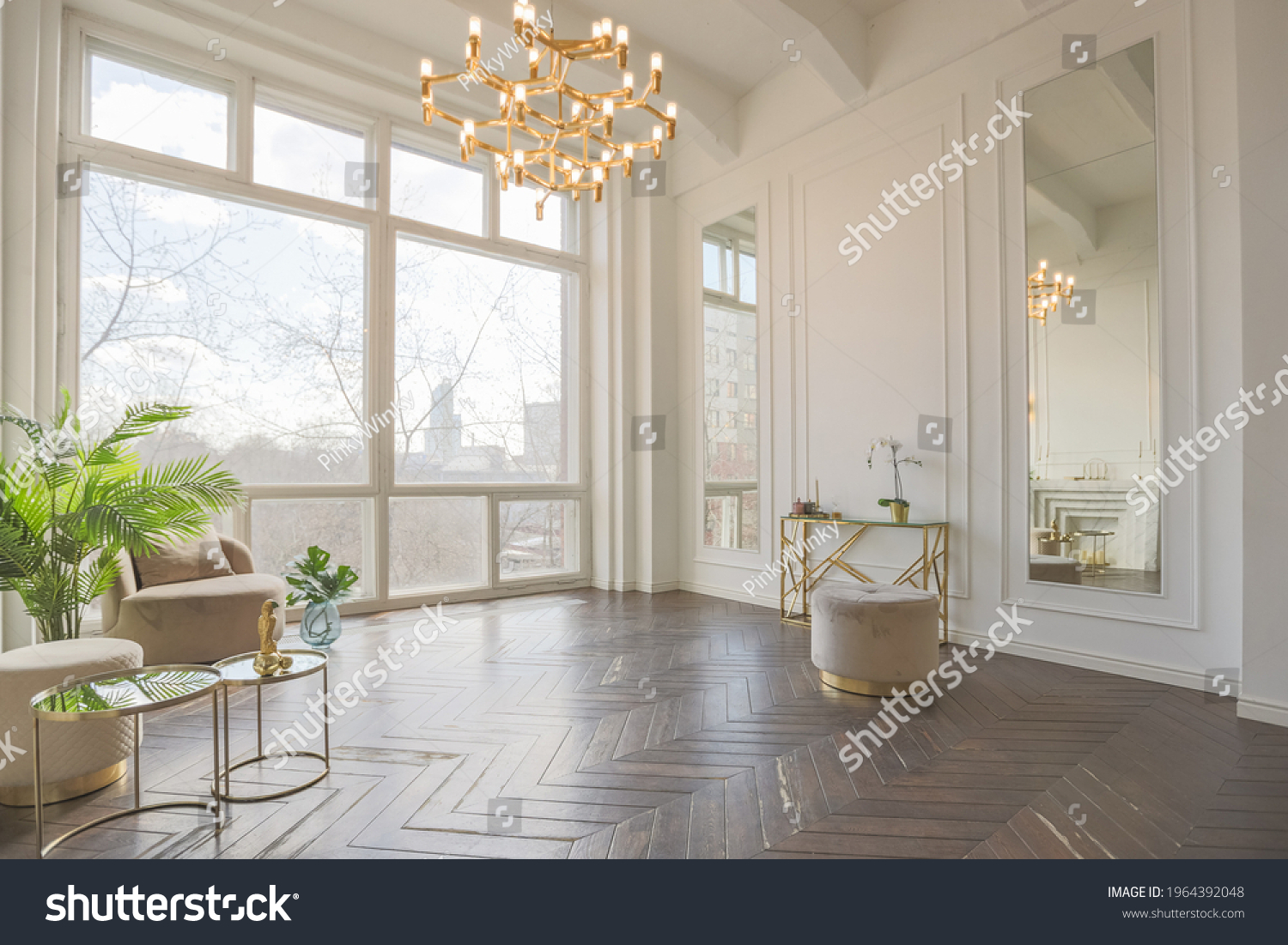 very light and bright interior of luxurious cozy living room with chic soft beige furniture with gold metallic elements, huge window to the floor and wooden parquet #1964392048