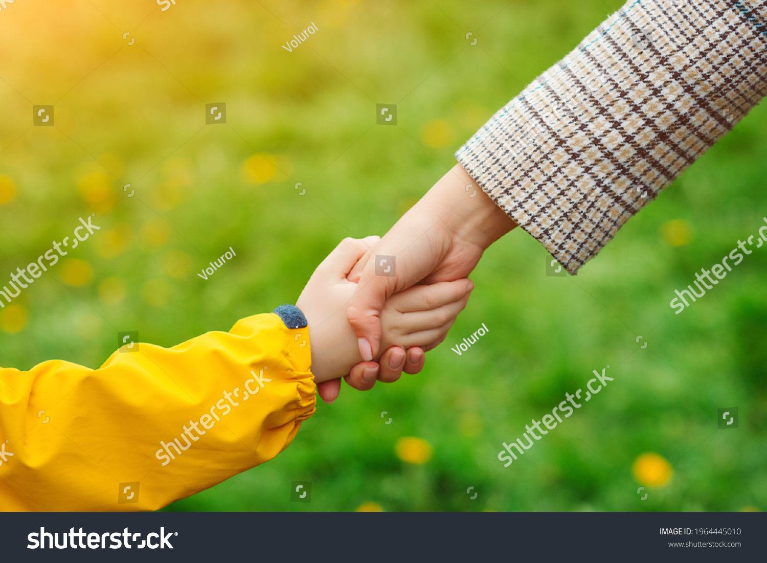 Mother and child hands reaching to each other. Support, help and trust. Parent holds the hand of a child on a walk. Kid and mother hands on nature background. Love, relationship and teamwork in family #1964445010