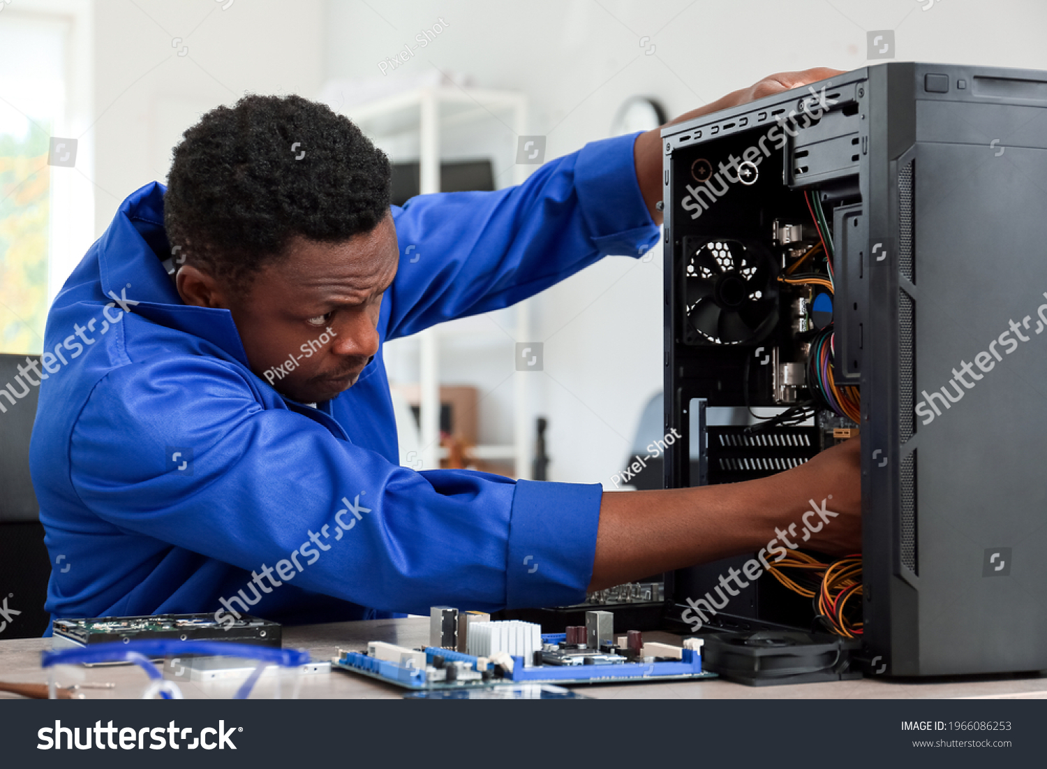 African-American technician repairing computer in service center #1966086253