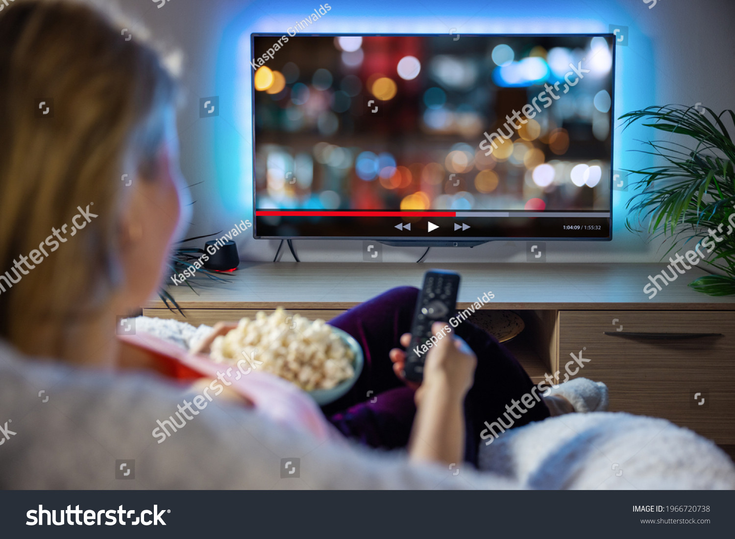 Woman relaxing at home in evening and watching TV #1966720738