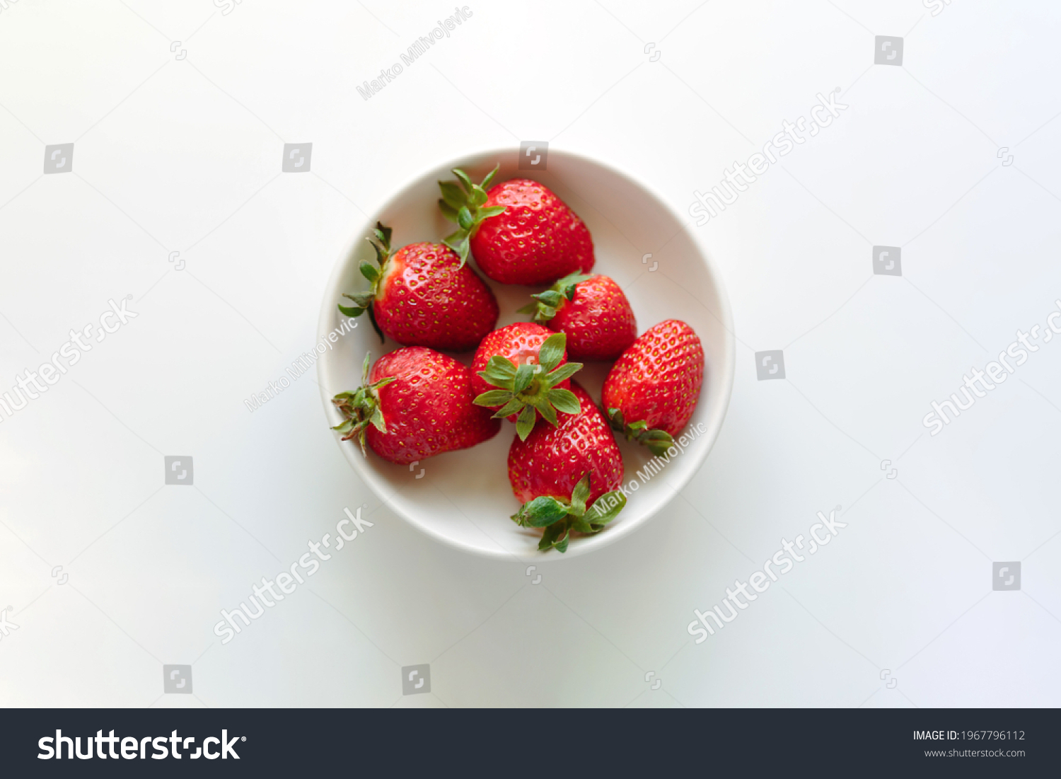 Heap of delicious fresh strawberries in ceramic bowl on white background with copy space. Close up, top view. #1967796112