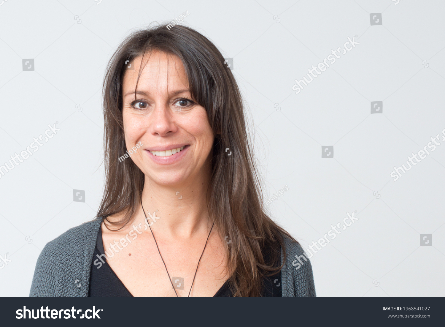 Headshot of a mediterranean woman aged 30-40 with a friendly big smile and white background #1968541027