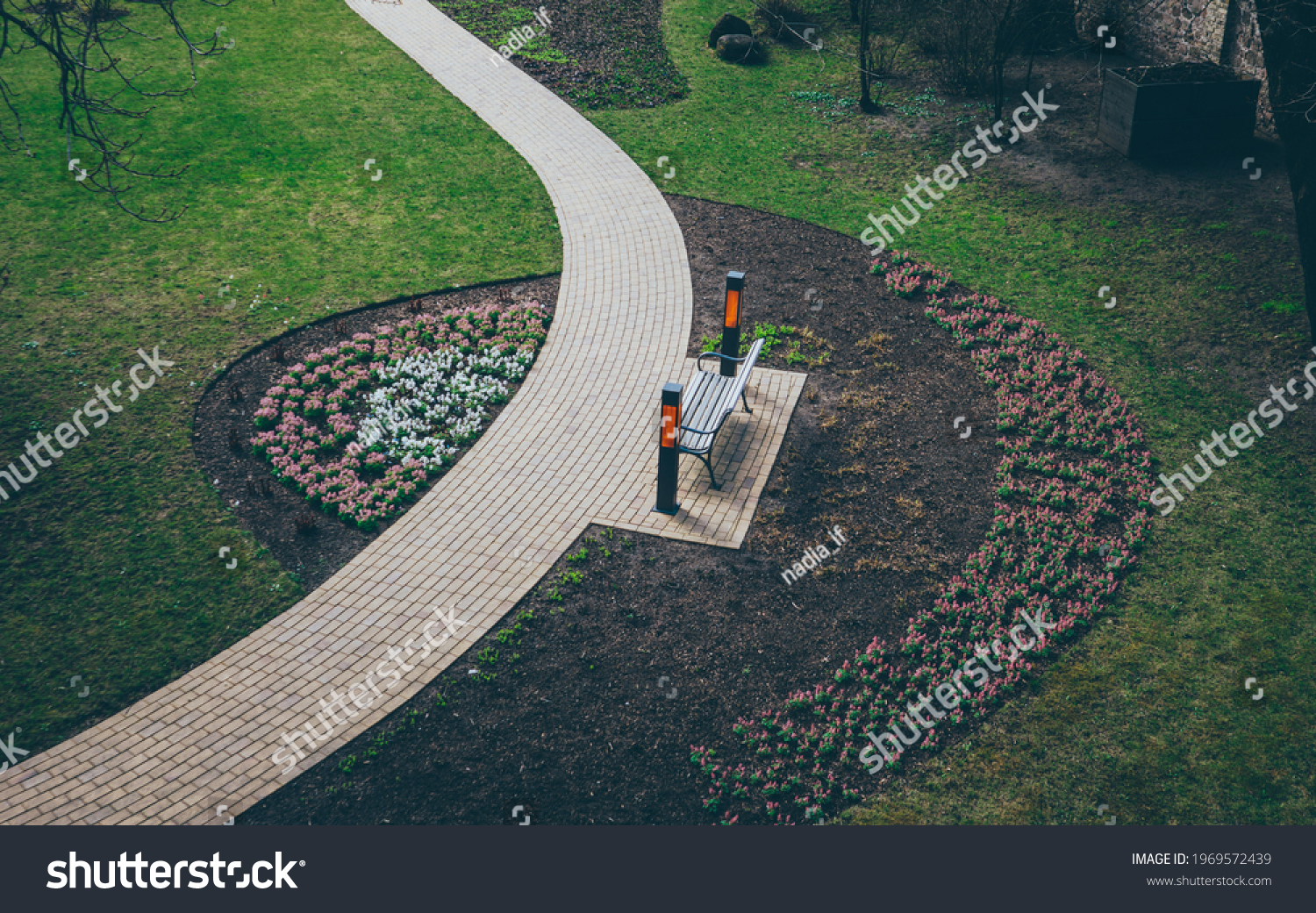 A footpath walkway in the park, the footpath passes by the bench, sidewalk, sideway #1969572439