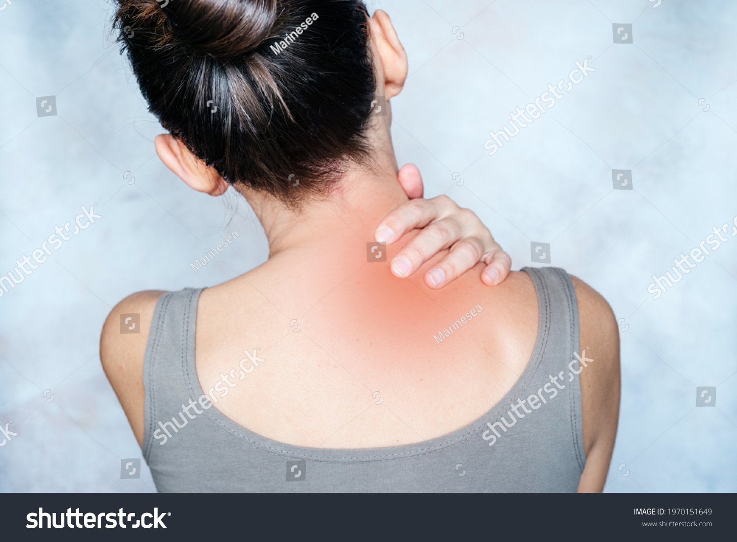 A woman massages her shoulder and neck pain points, trigger point massage, physiotherapy and massage concept #1970151649