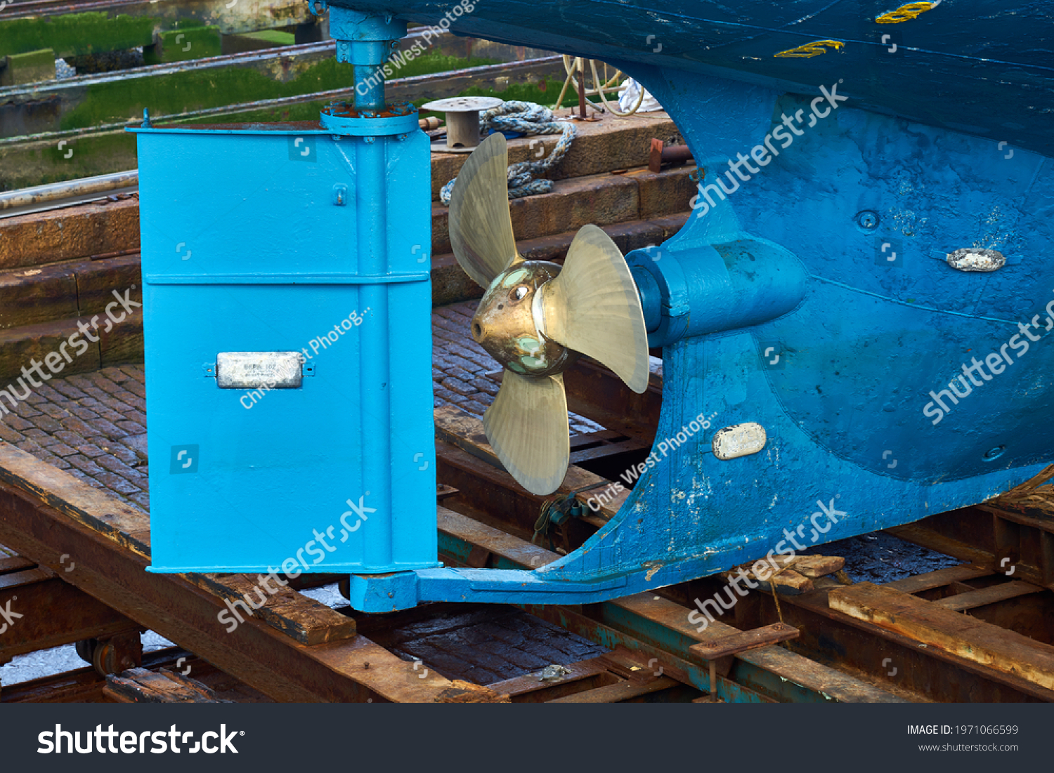 The rudder and propeller of a boat in dry dock #1971066599