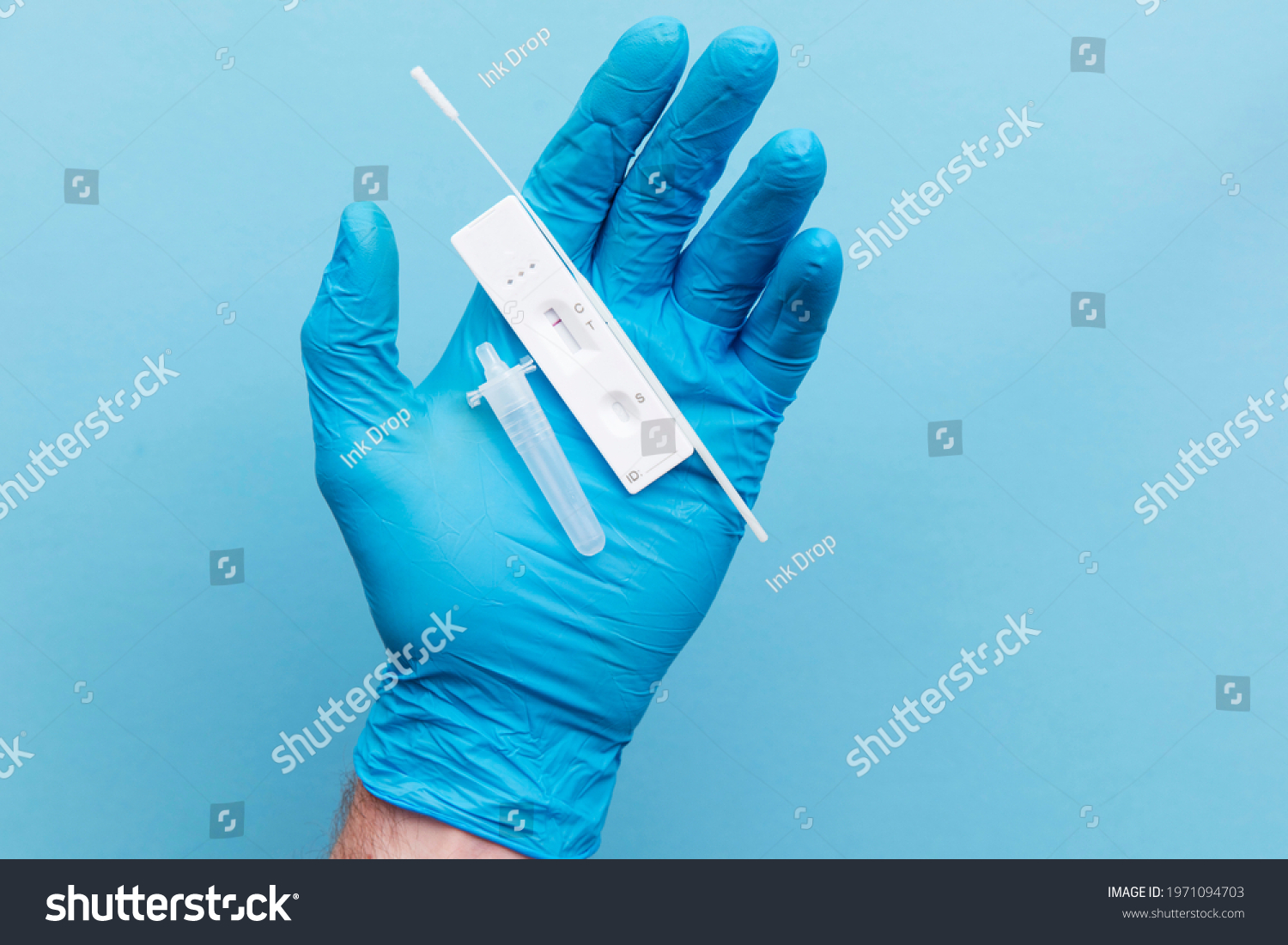 Doctor in blue gloves using a lateral flow covid-19 testing kit #1971094703