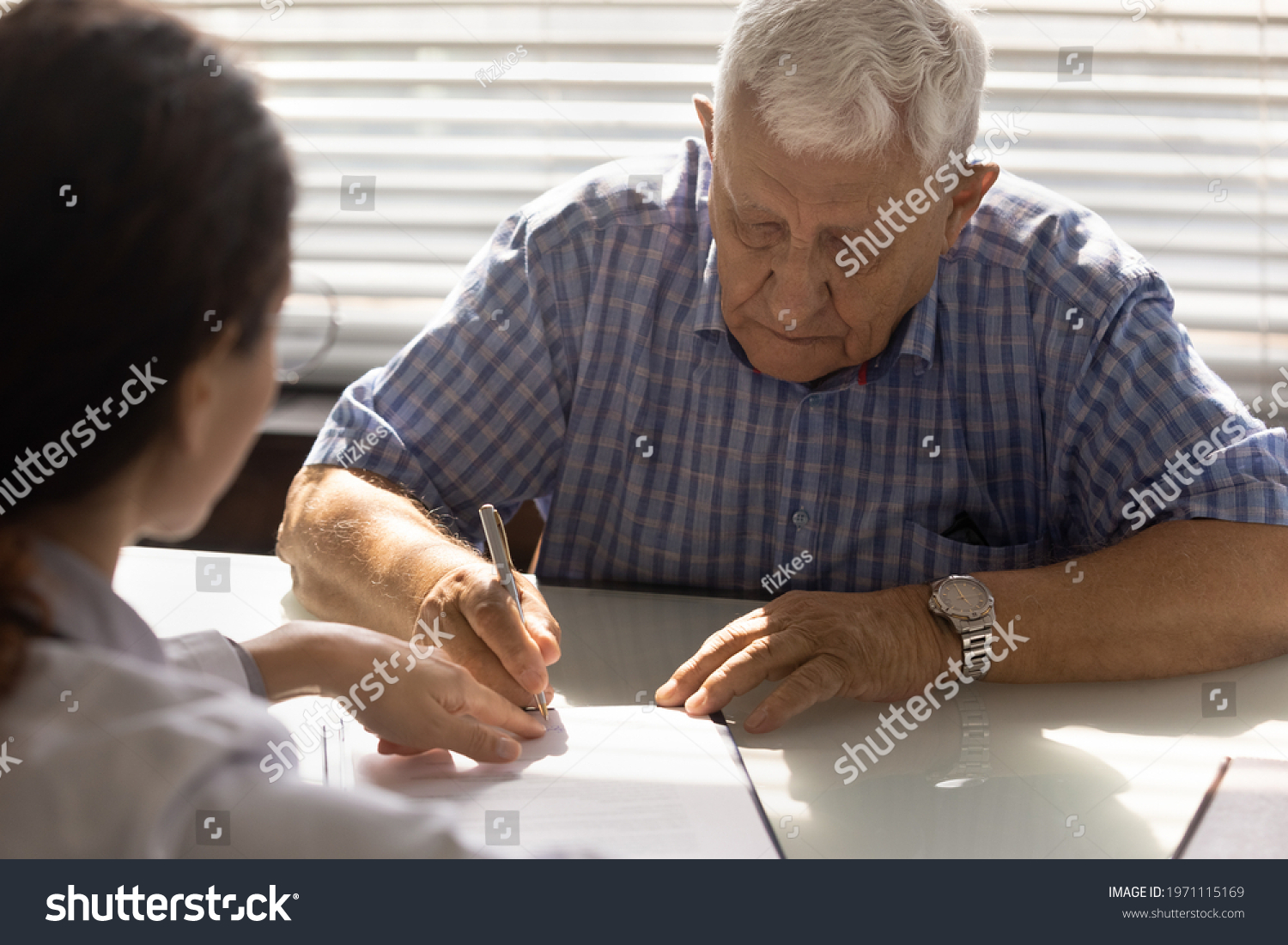 Sign here please. Sick elderly male affirming treatment plan by personal signature on appointment with doctor. Retired man patient sign contract on provision of health care service at physician office #1971115169