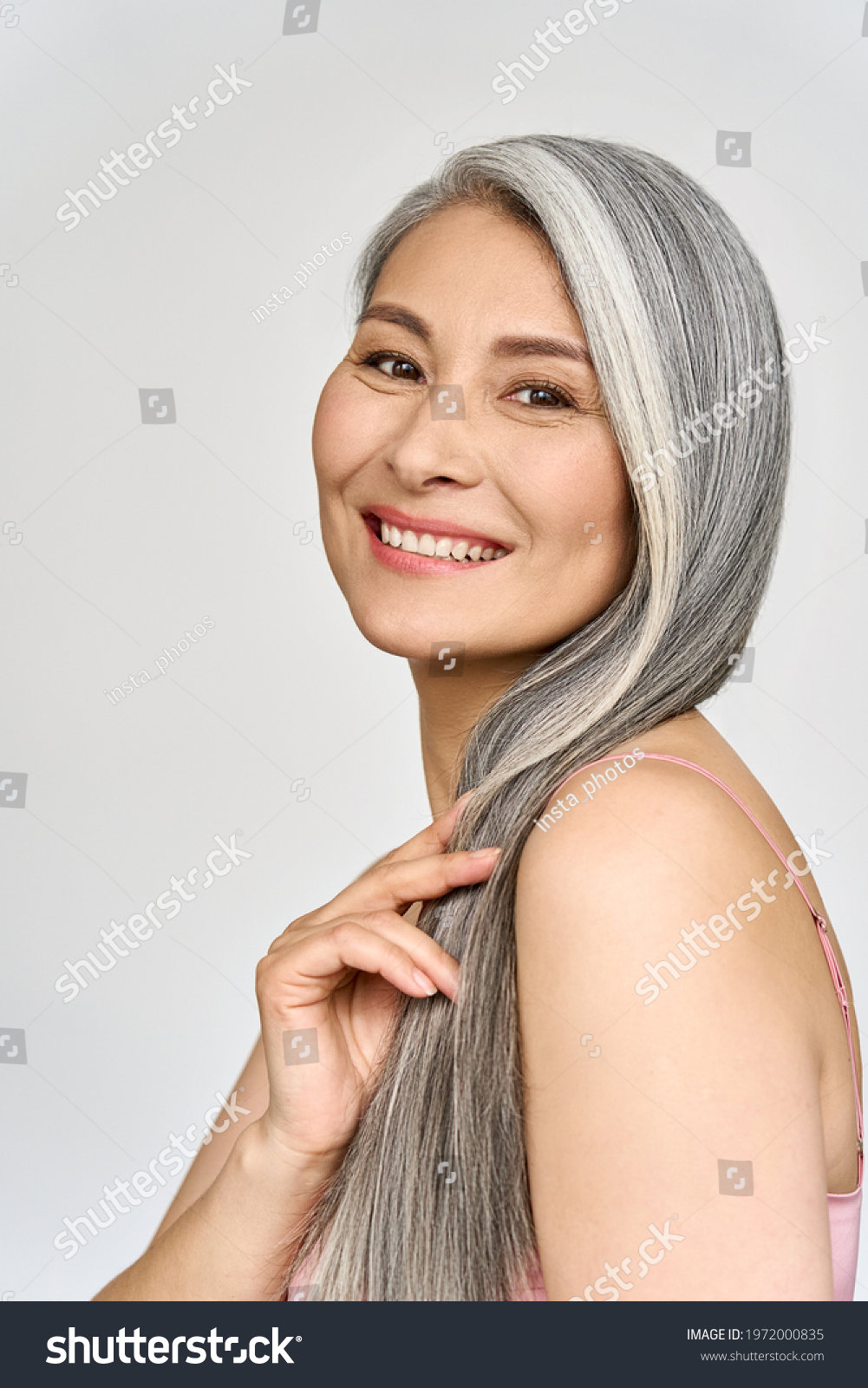 Vertical portrait of gorgeous happy joyful middle aged mature cheerful asian woman, senior older 50s gray haired lady isolated on white. Ads of aesthetic medicine spa salon hair care. #1972000835