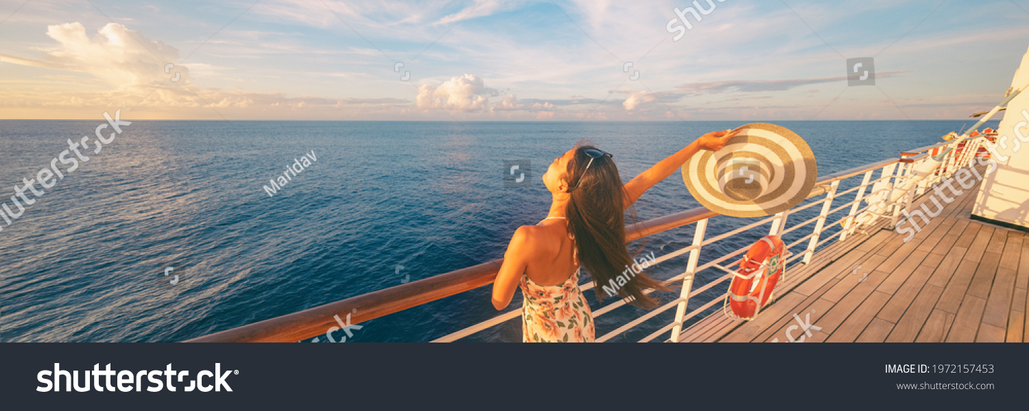 Happy cruise woman relaxing on deck feeling free watching sunset from ship on Caribbean travel vacation. Panoramic banner of sea and boat. #1972157453