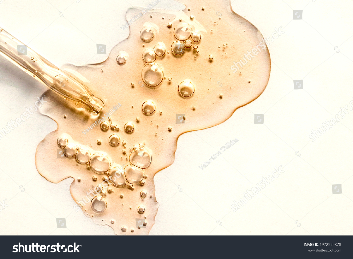 Yellow texture of a drop of whey or olive oil on a white background. Transparent sample of cosmetic gel with bubbles. Golden acid cream. Vitamin c. A drop of honey. Hyaluronic acid. #1972599878