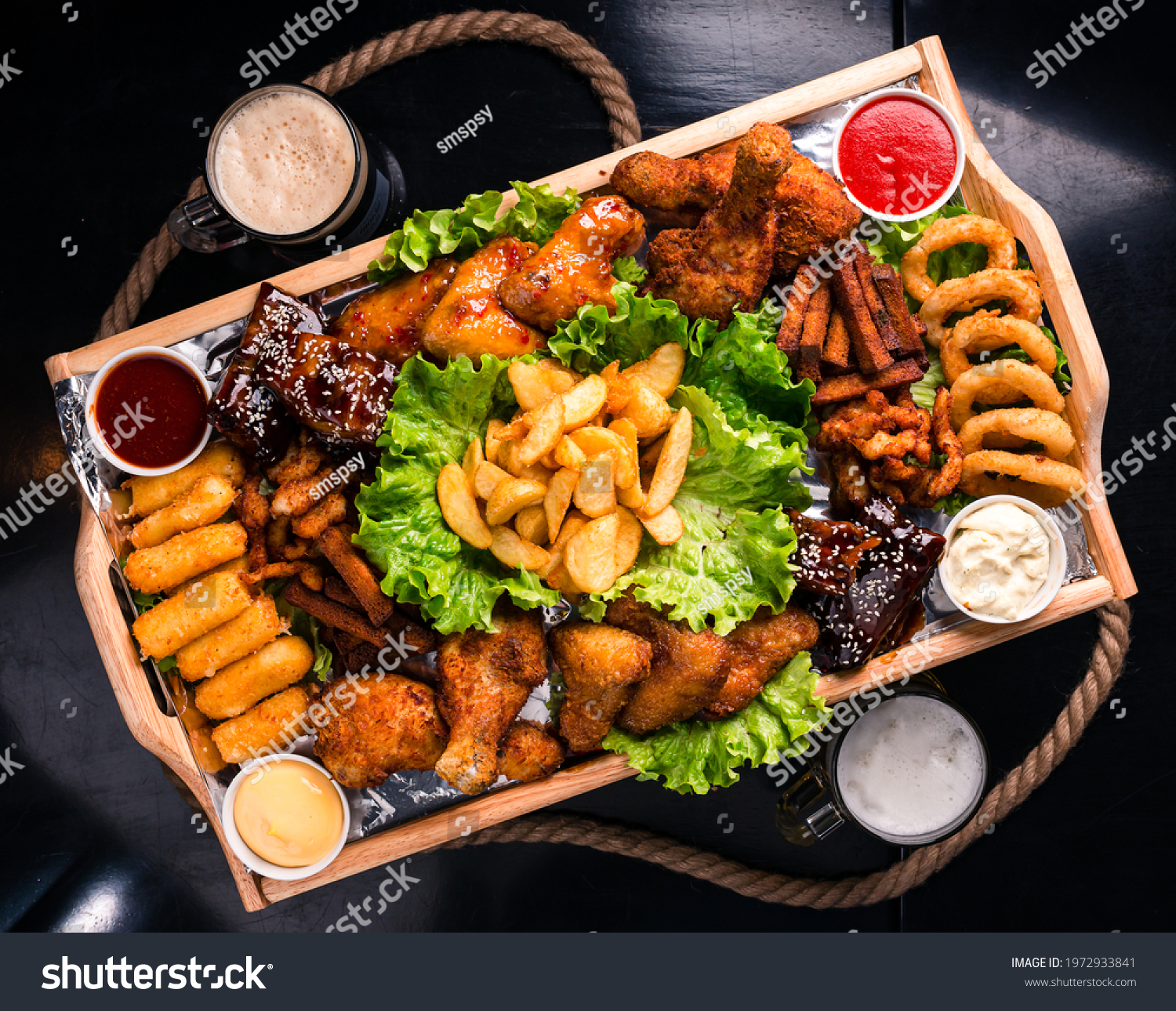 Large beer plate, large set of beer snacks. assorted snacks deep-fried beer. Food for a holiday for a large company. hot meat snacks for beer served on wooden dish board top view, flat lay #1972933841
