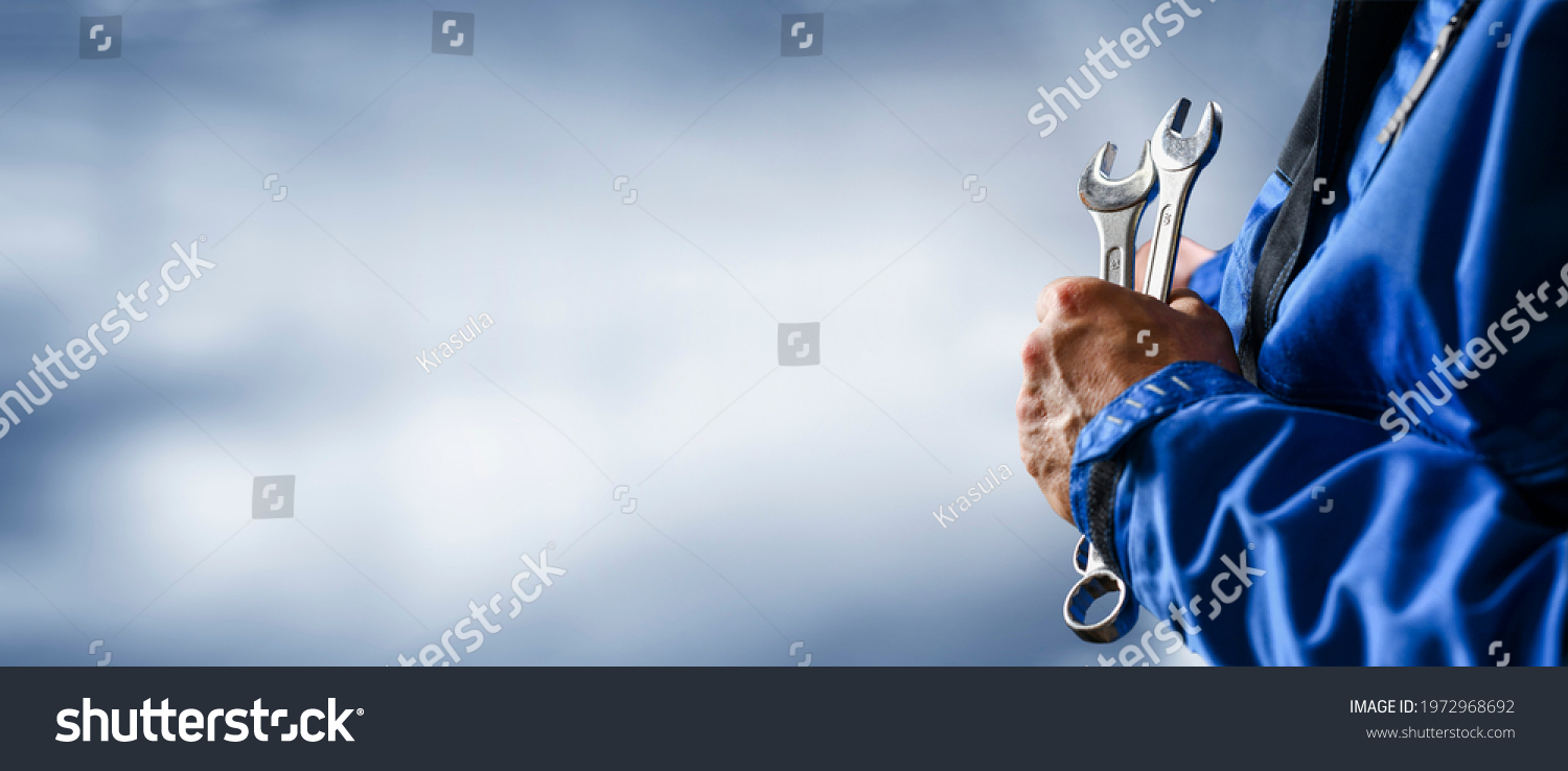 Auto mechanic working on car broken engine in mechanics service or garage. Transport maintenance wrench detial Wide banner or panorama photo. #1972968692