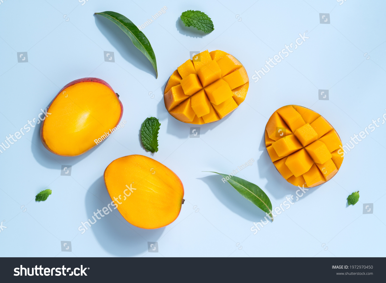 Mango design concept. Top view of diced fresh mango fruit pattern on blue table background. #1972970450