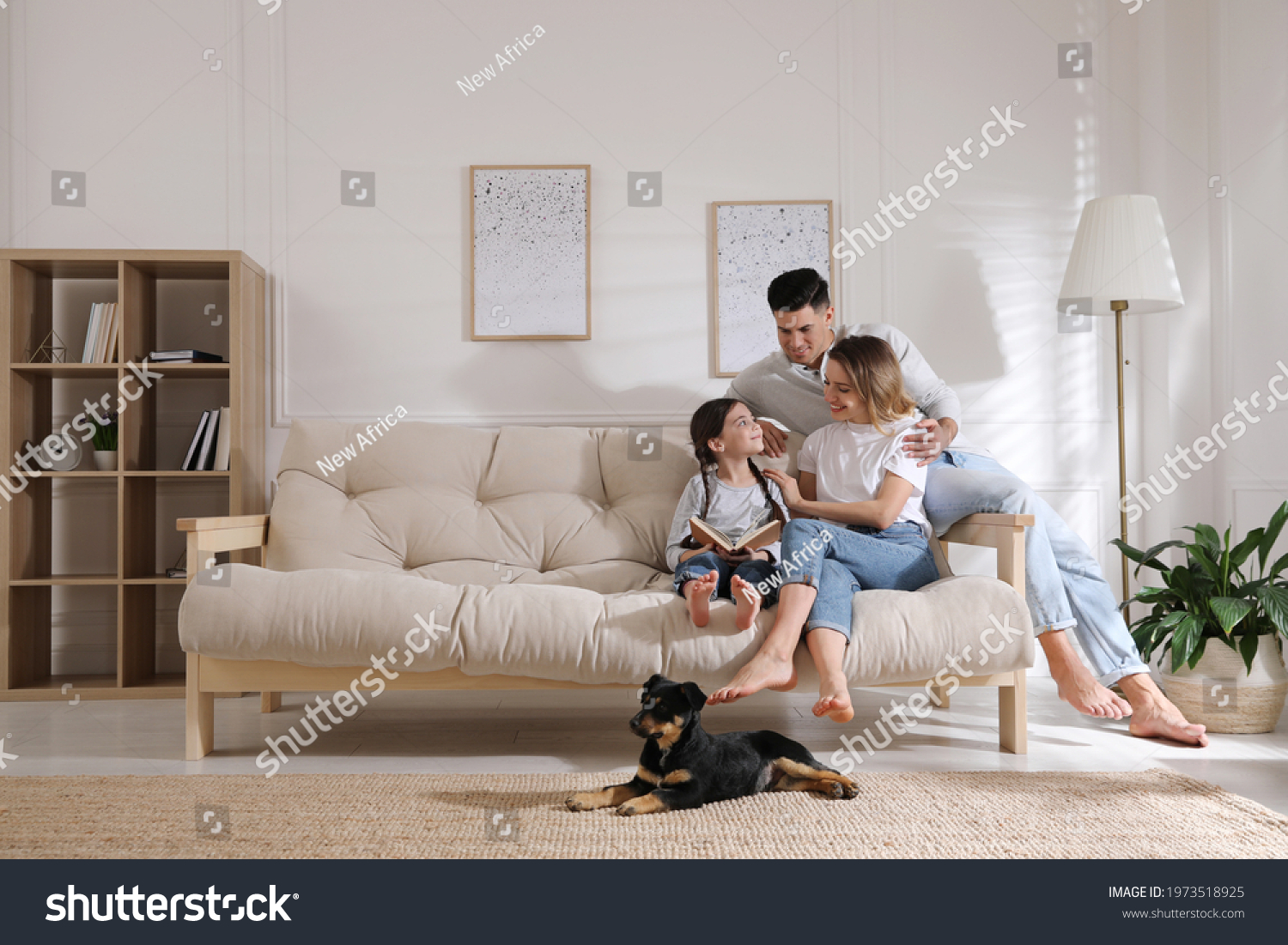 Happy family on sofa and puppy in living room #1973518925