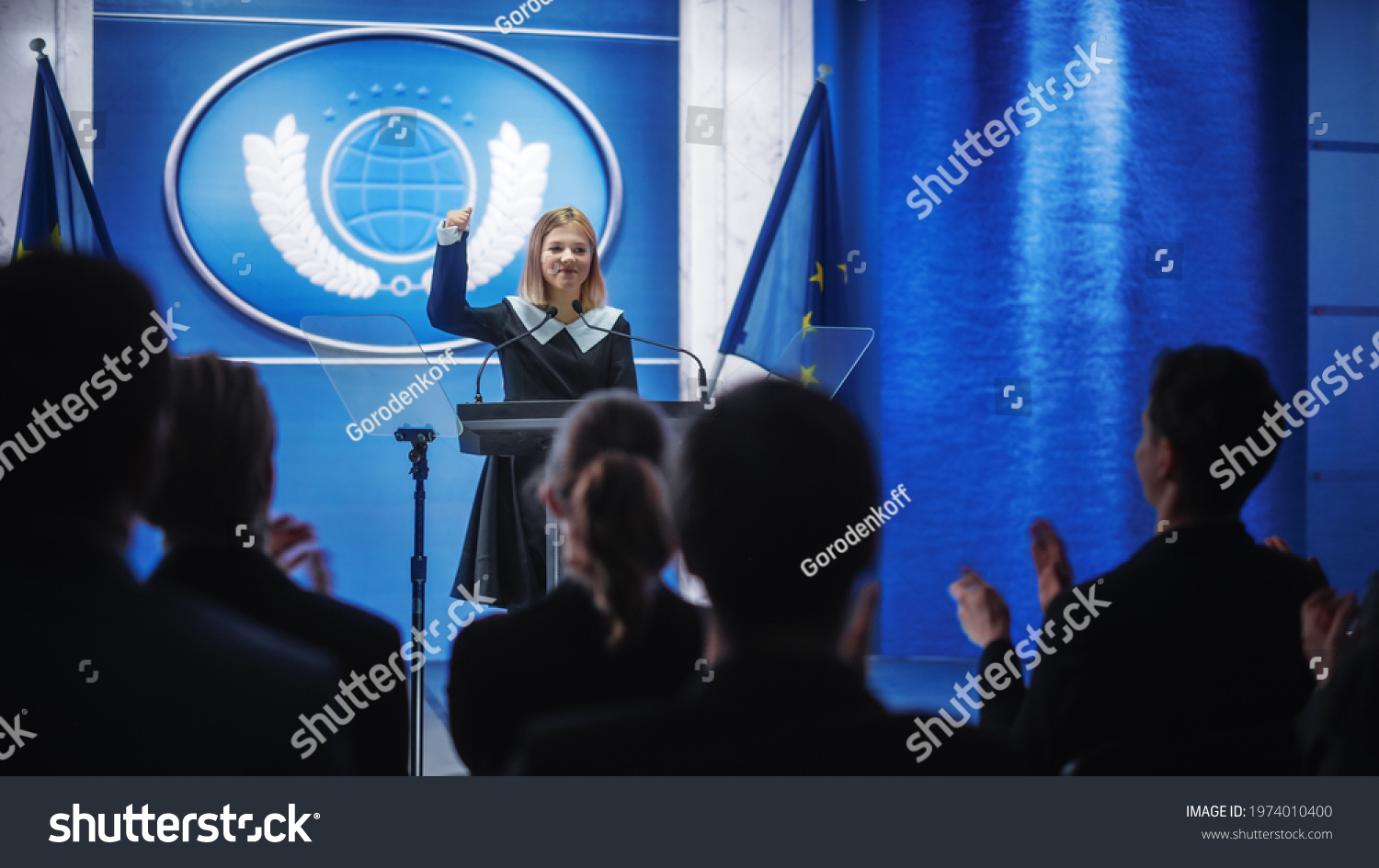 Young Girl Activist Delivering an Emotional and Powerful Speech at Press Conference in Government Building. Child Speaking to Congress at Summit Meeting. Backdrop with European Union Flags. #1974010400