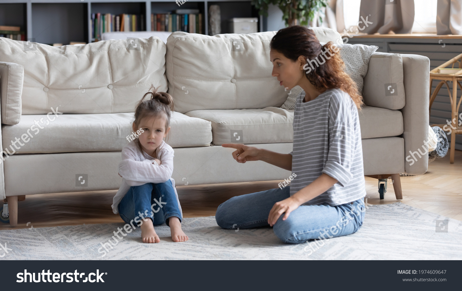 Strict young Caucasian mother talk lecture ill-behaved stubborn small preschooler daughter at home. Serious mom scold unhappy naughty little girl child kid. Family fight, generation gap concept. #1974609647