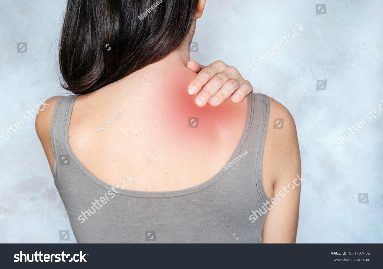 A woman massages her shoulder and neck pain points, trigger point massage, physiotherapy, and massage concept #1974707486