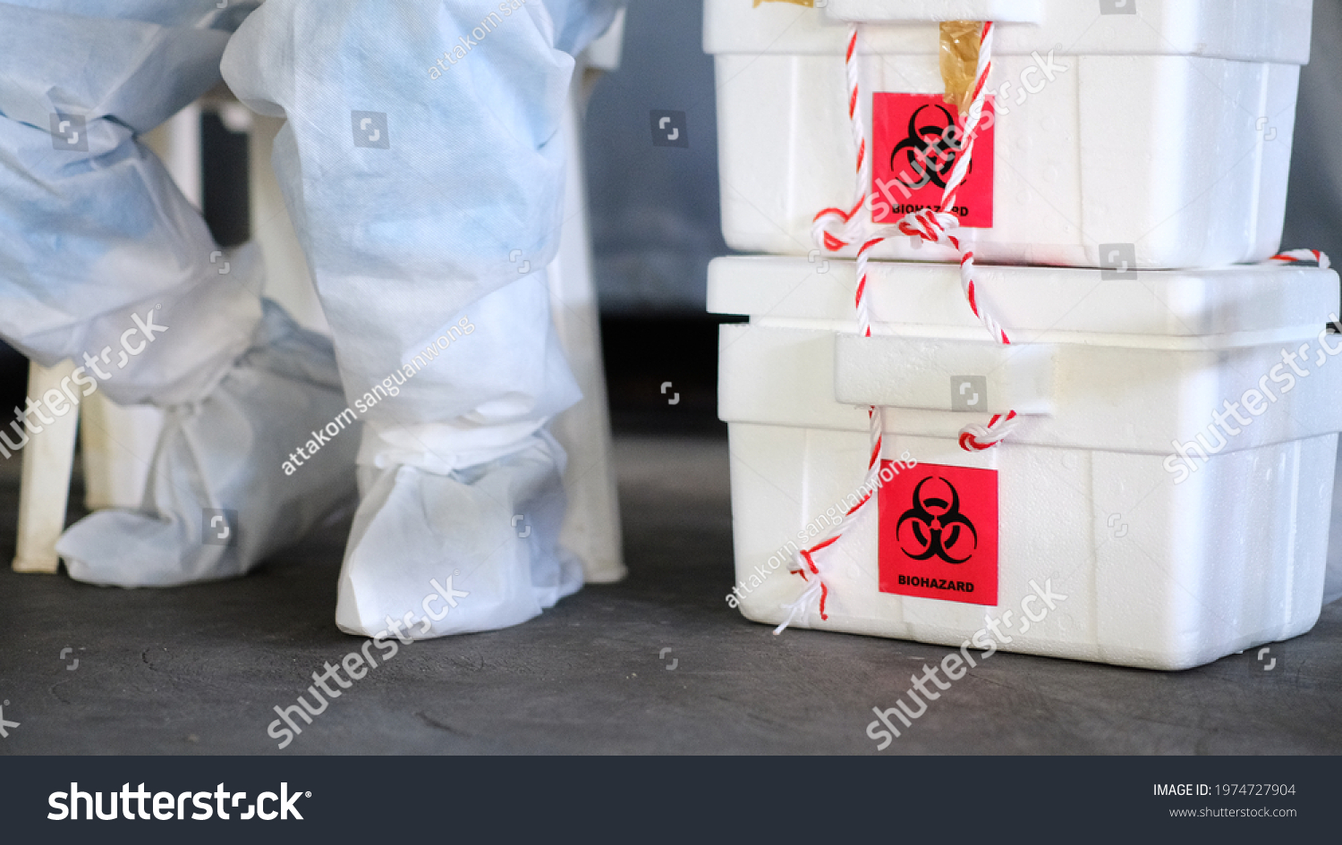 The biohazard box stores a swab test covid-19 and a doctor wearing a PPE protective suit. #1974727904