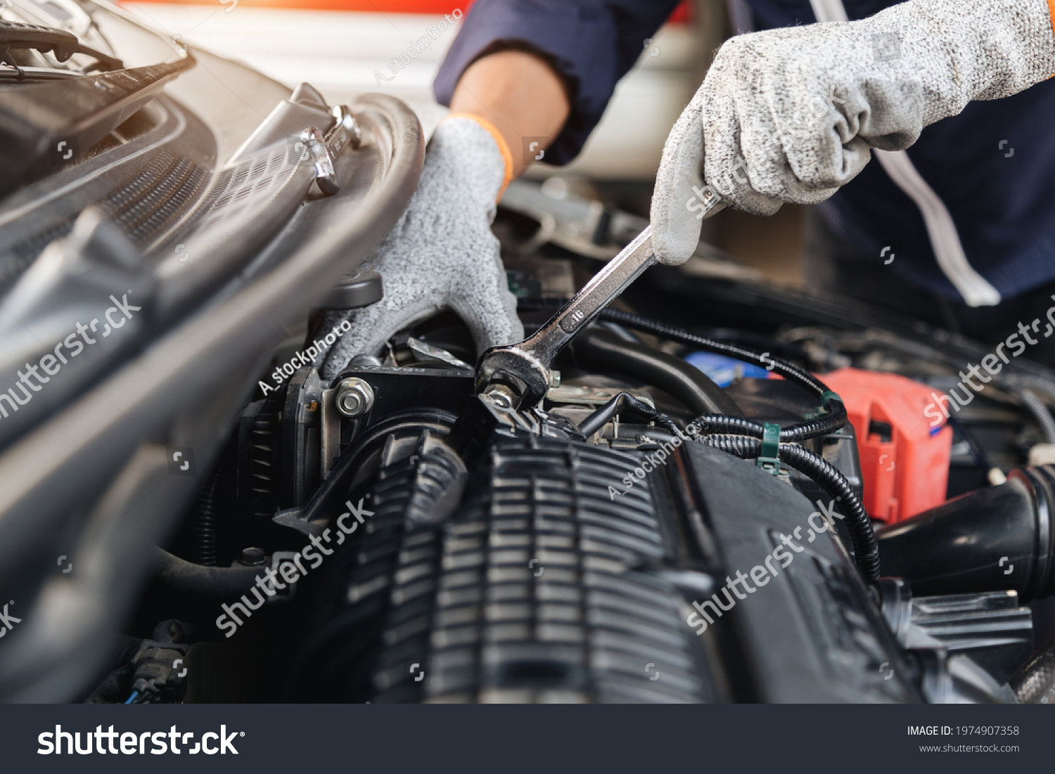 Automobile mechanic repairman hands repairing a car engine automotive workshop with a wrench, car service and maintenance,Repair service. #1974907358