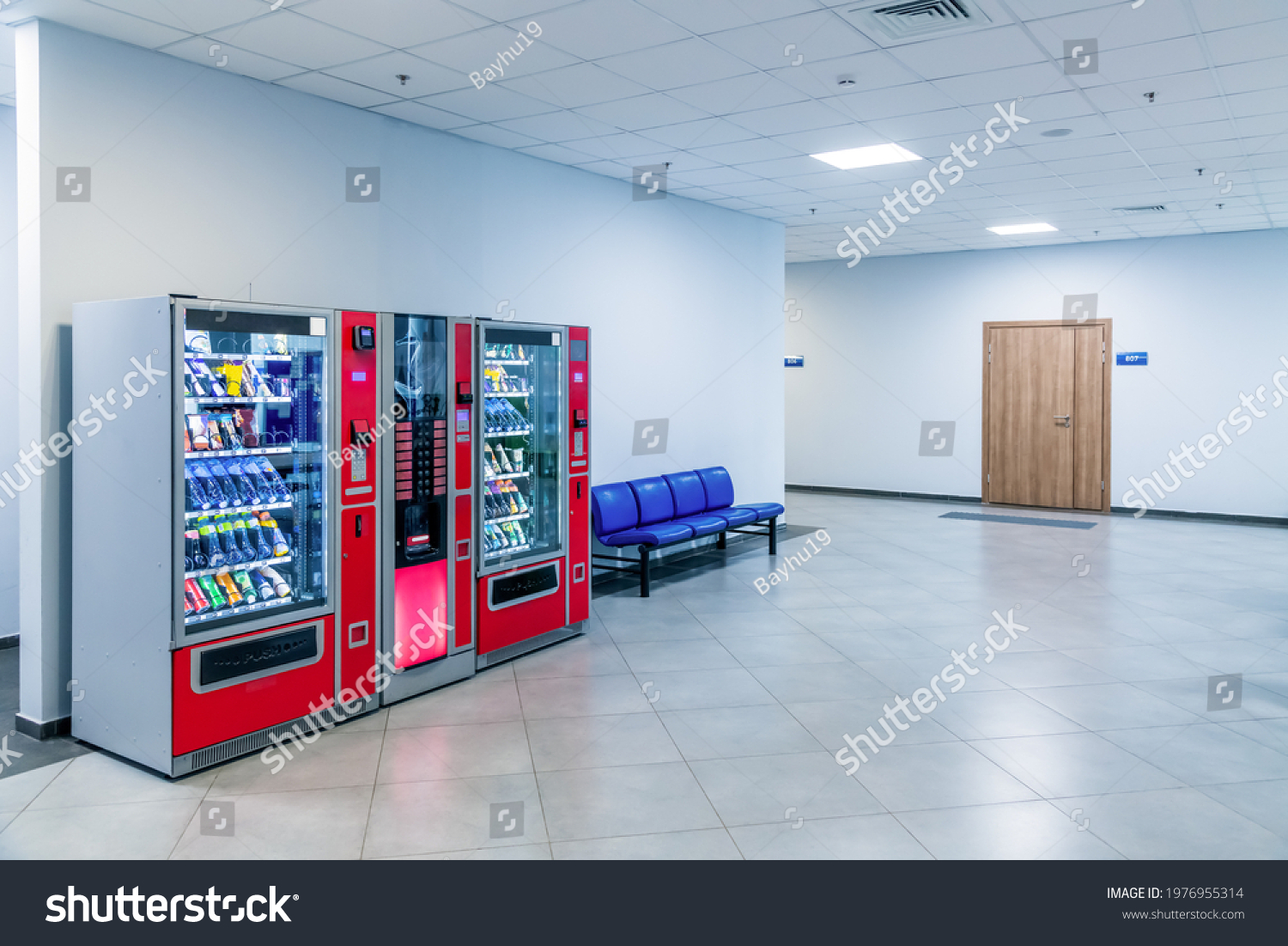 Group of red vending machines stands by the wall. Glare is reflected on a black screen. No people. Copy space for your text. Small business theme. #1976955314