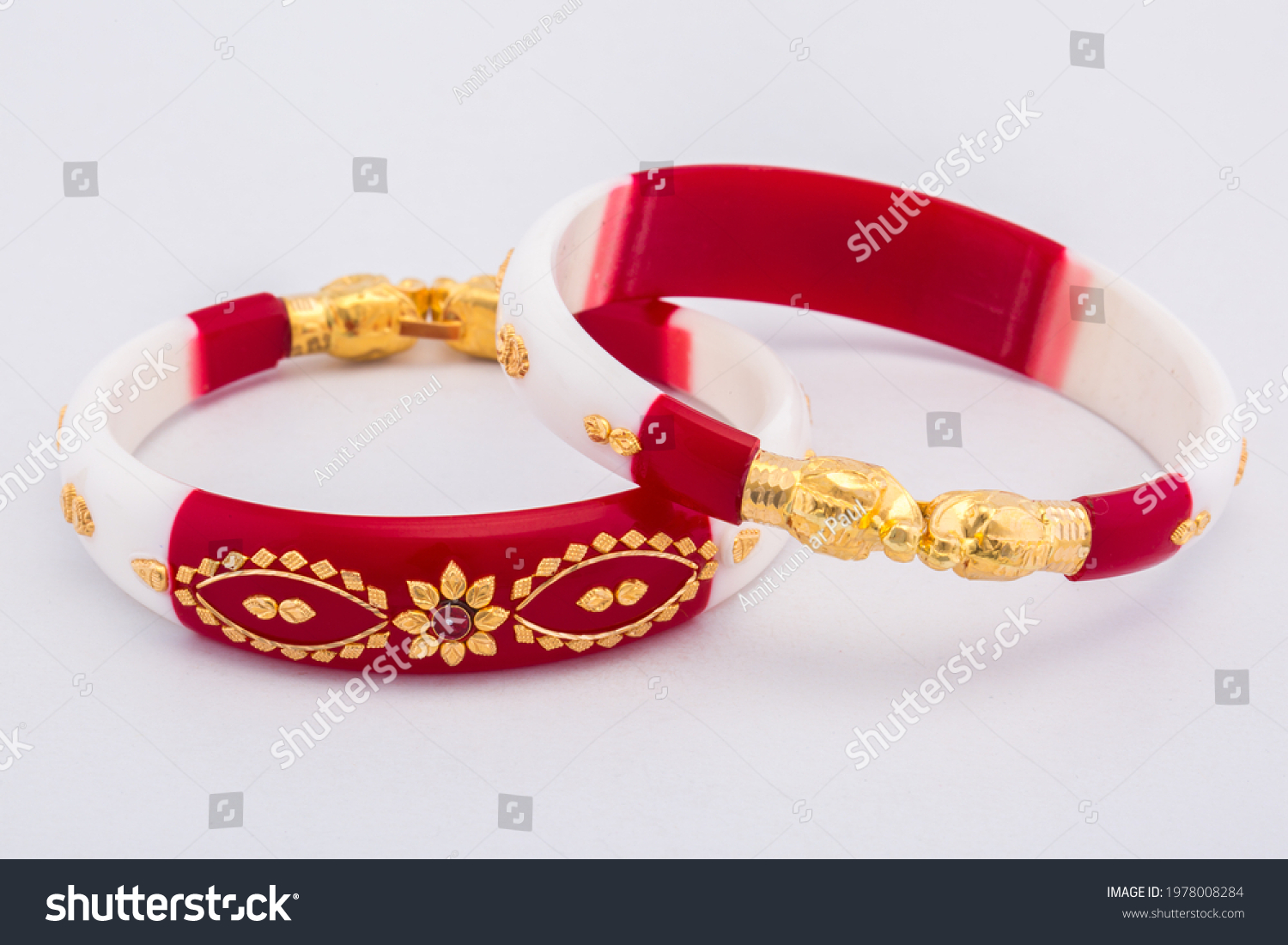 Bangle made with a gold and plastic. Isolated on white background. Jewelry stock photo. Red color bangle. Top view. #1978008284