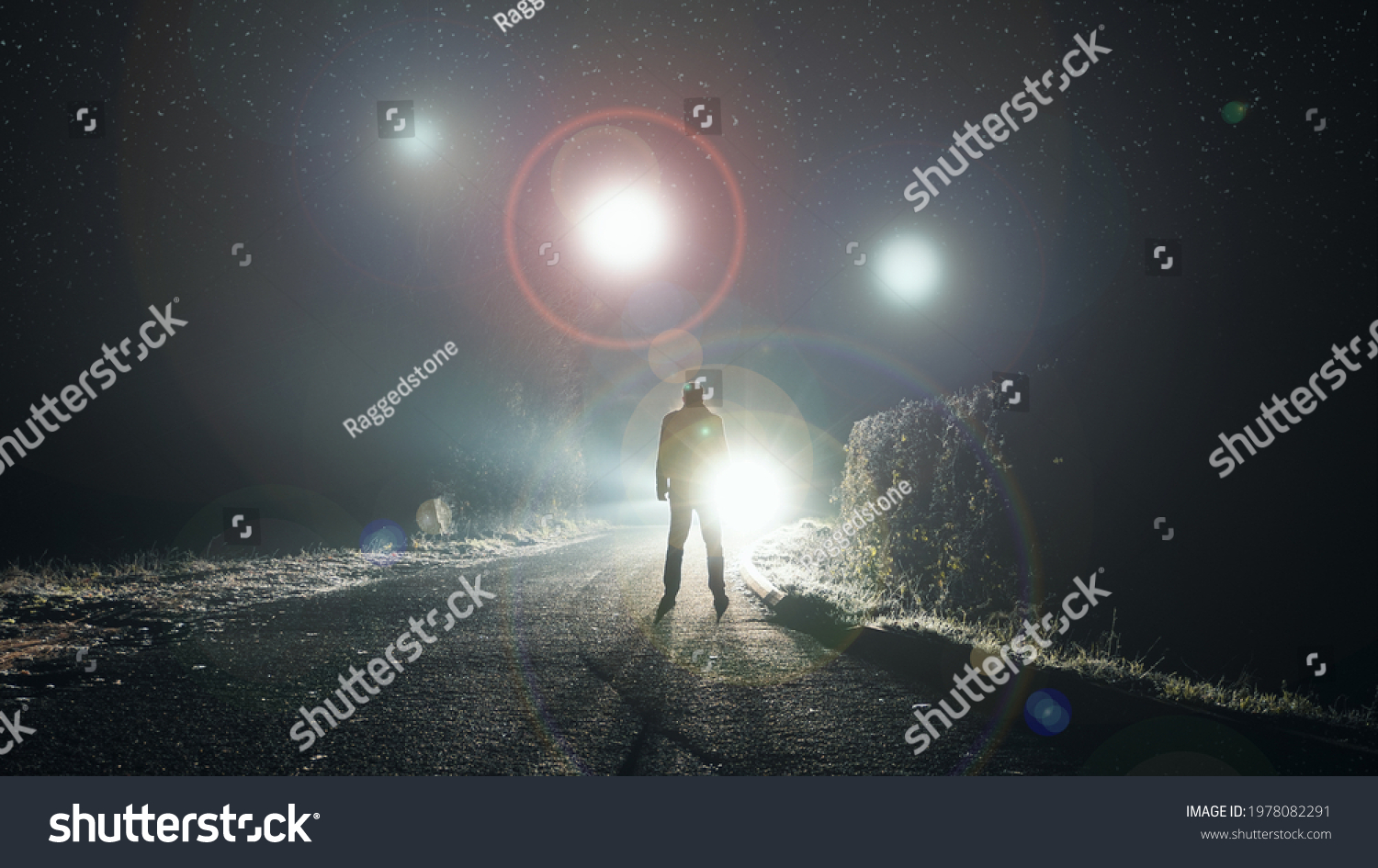 UFO concept. Glowing orbs, floating above a misty road at night. With a silhouetted figure looking at the lights.                #1978082291