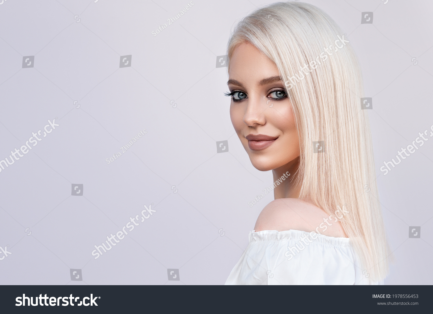 Beautiful girl with hair coloring in ultra blond. Stylish hairstyle done in a beauty salon. Fashion, cosmetics and makeup #1978556453