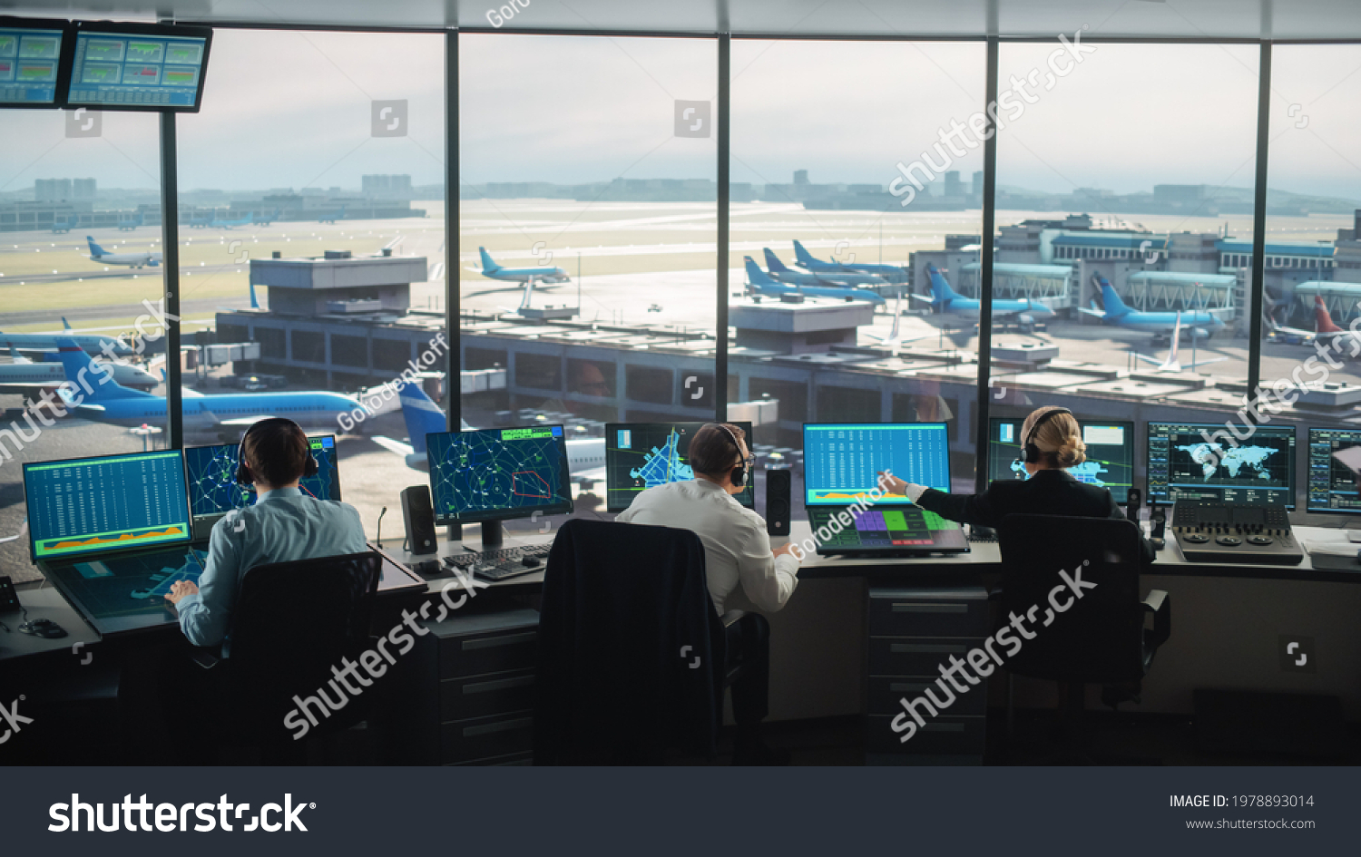 Diverse Air Traffic Control Team Working in a Modern Airport Tower. Office Room is Full of Desktop Computer Displays with Navigation Screens, Airplane Departure and Arrival Data for Controllers. #1978893014