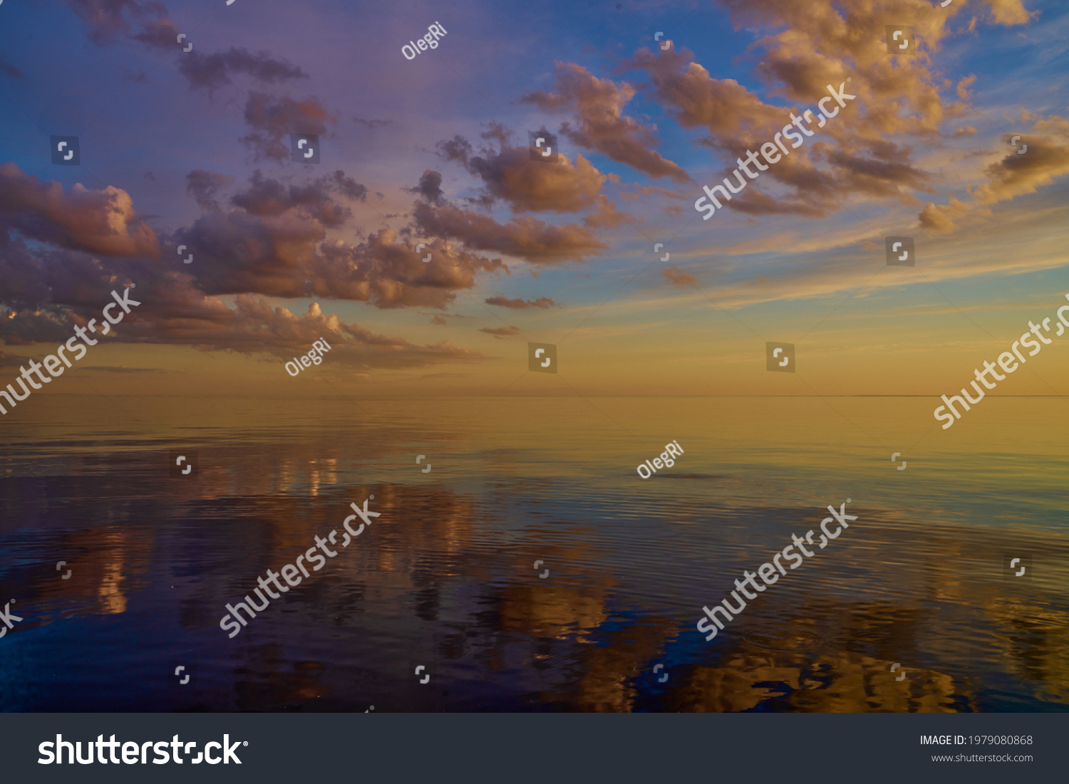 Beautiful sunset over sea with reflection in water, majestic clouds in the sky. #1979080868
