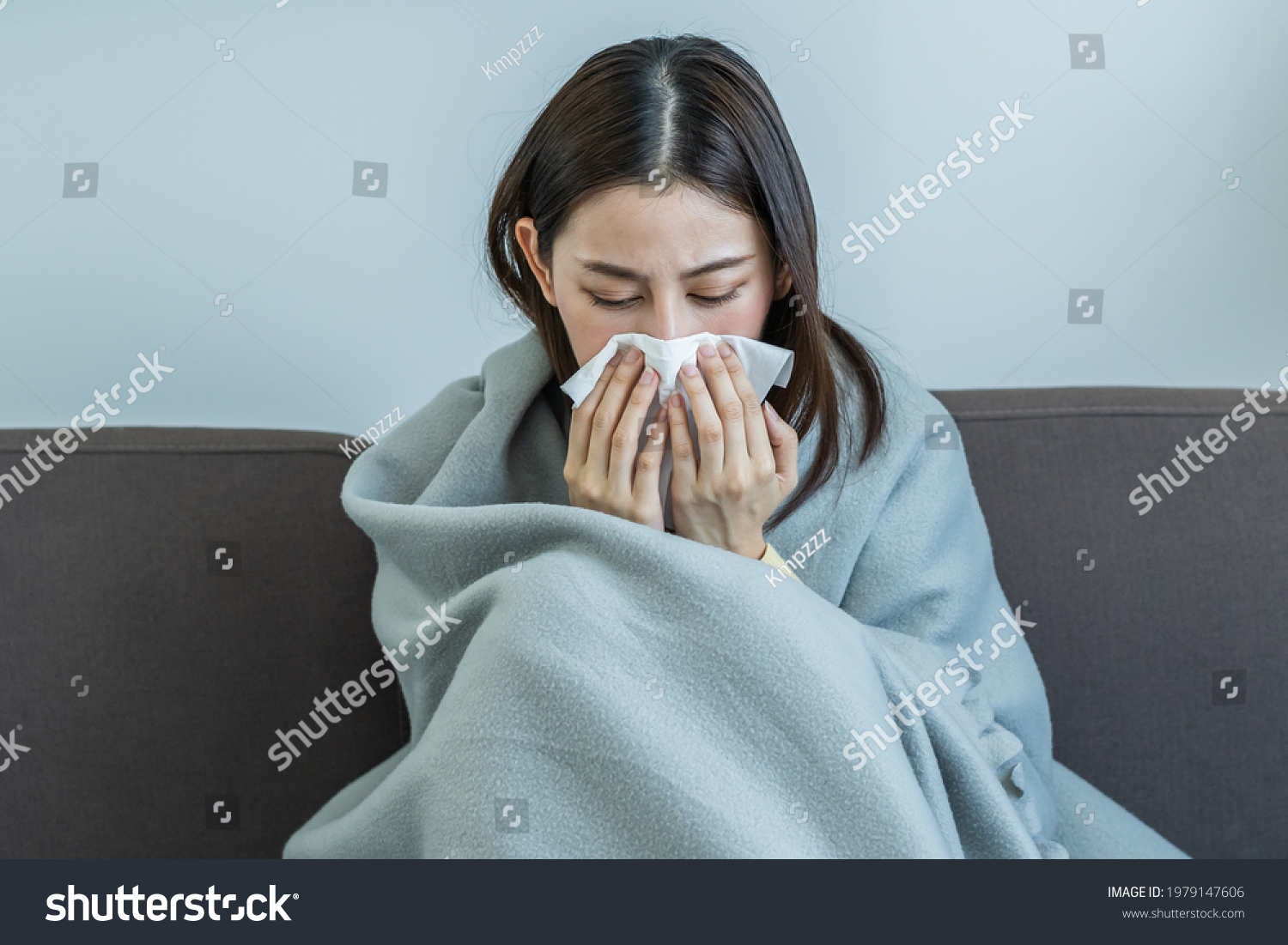 Sick, Coronavirus covid-19 asian young woman, girl headache under blanket have a fever, flu and use tissues paper sneezing nose, runny sitting on sofa bed at home. Health care on virus person. #1979147606