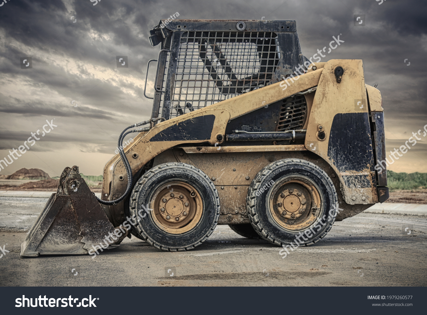 a close up of a bobcat or a skid steer loader used in construction,landscaping and agriculture. It has a many purpose bucket in the front. #1979260577